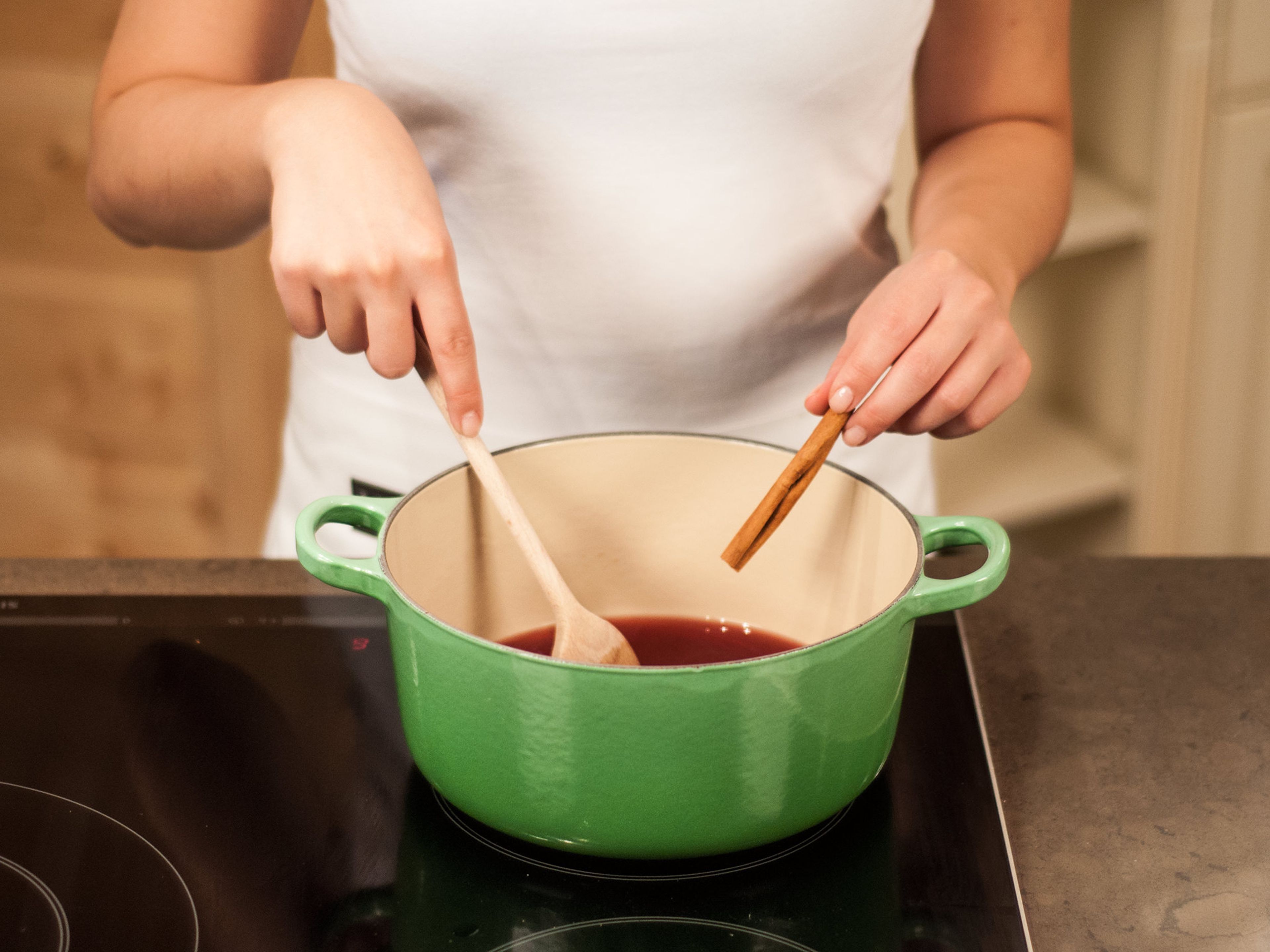 Before serving, prepare the sauce. Add red wine, raspberry brandy, the remaining sugar, and a cinnamon stick to a saucepan. Bring everything to a boil and let simmer until the sugar has fully dissolved.