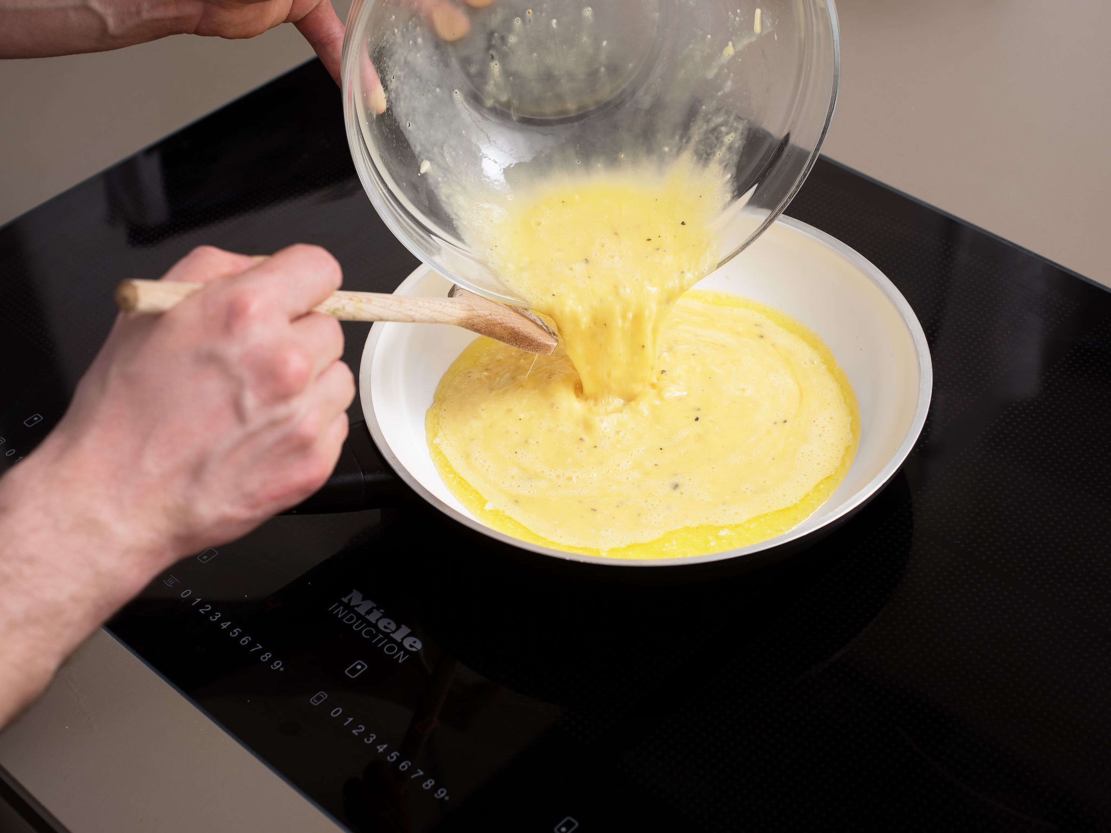 Butter in einer Pfanne über mittlerer Hitze schmelzen lassen. Die Ei-Mischung in die Pfanne geben und ca. 10 Min. braten. Mit einem Kochlöffel vorsichtig rühren, bis das Rührei seidig und cremig ist.