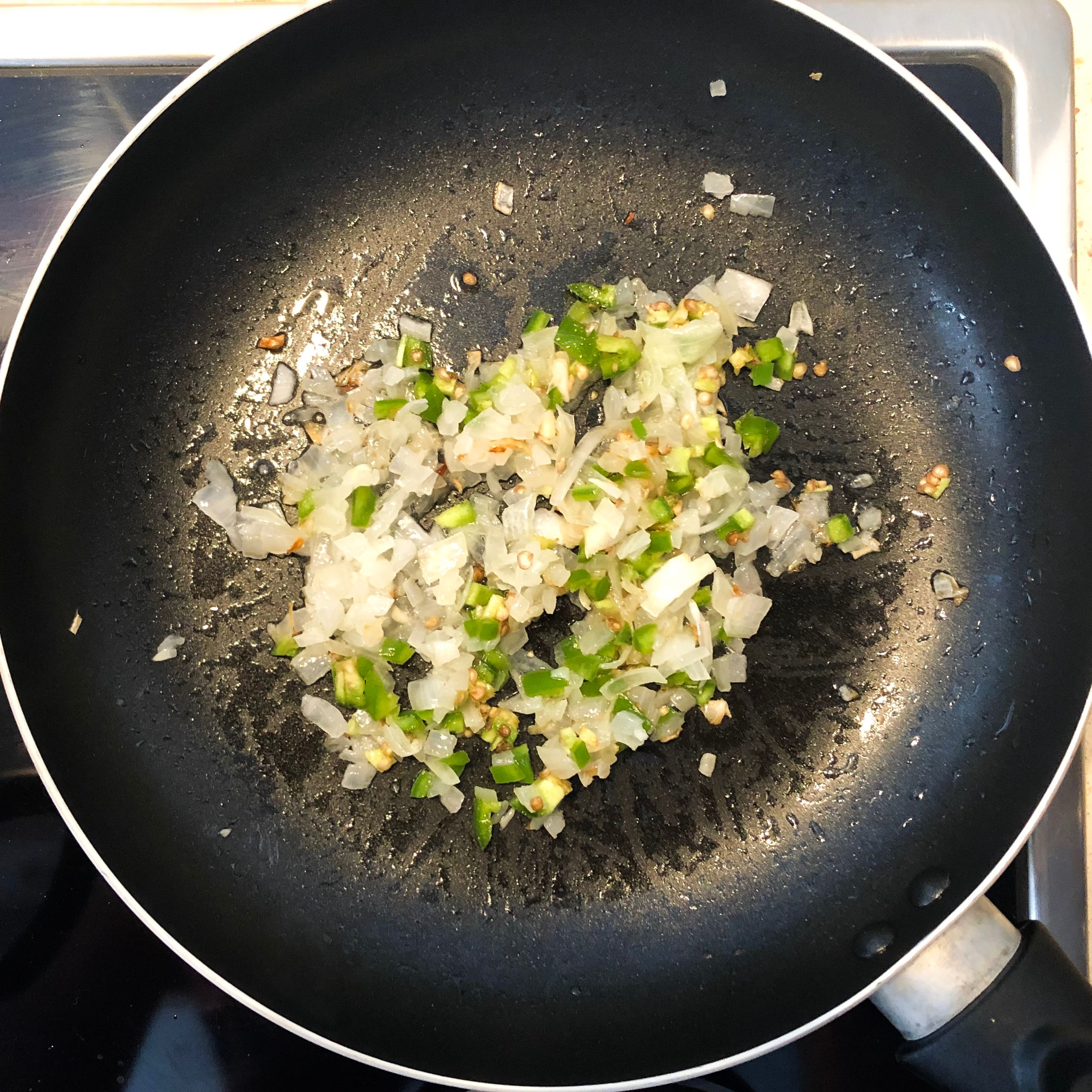 Third step: grab a pan and add some vegetable oil. Turn your stove to medium heat. When warm, add your minced onion & jalapeños. Move it around and let it cook for about 3-5 min...
