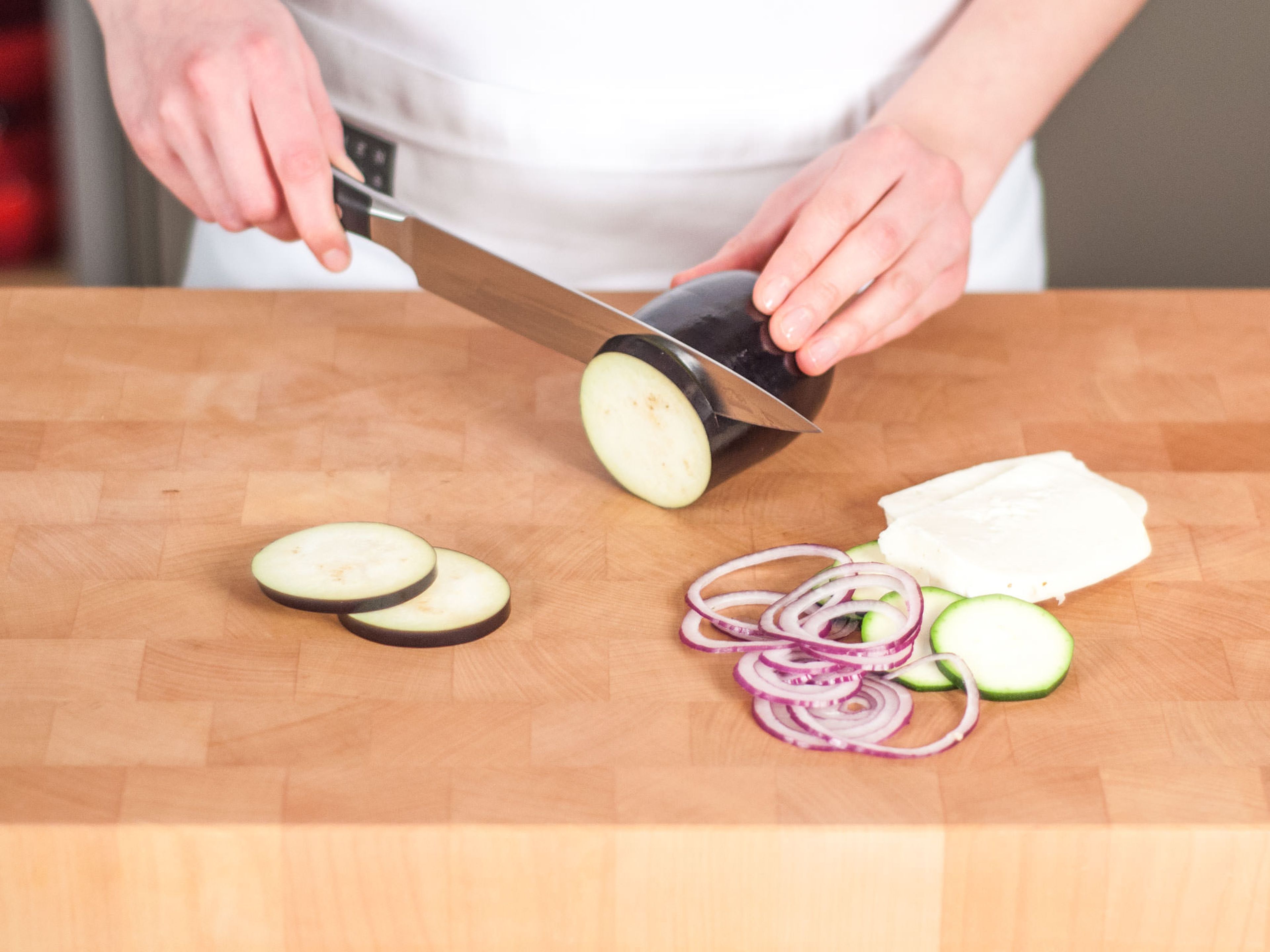 Cut onions into rings. Slice Halloumi, zucchini, and eggplant.