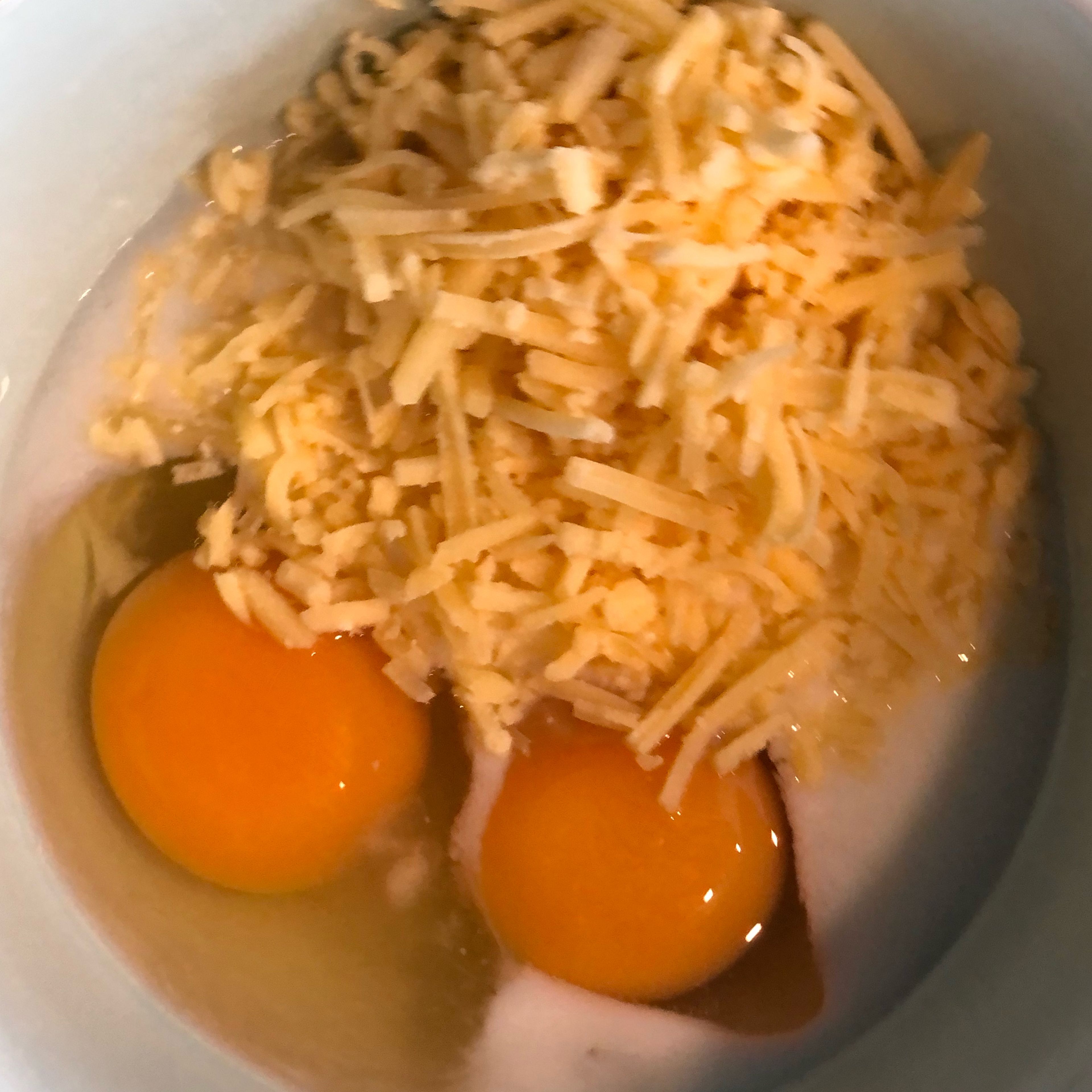 Add the cheese (as much as you like), 2 eggs and milk into a bowl and mix together!