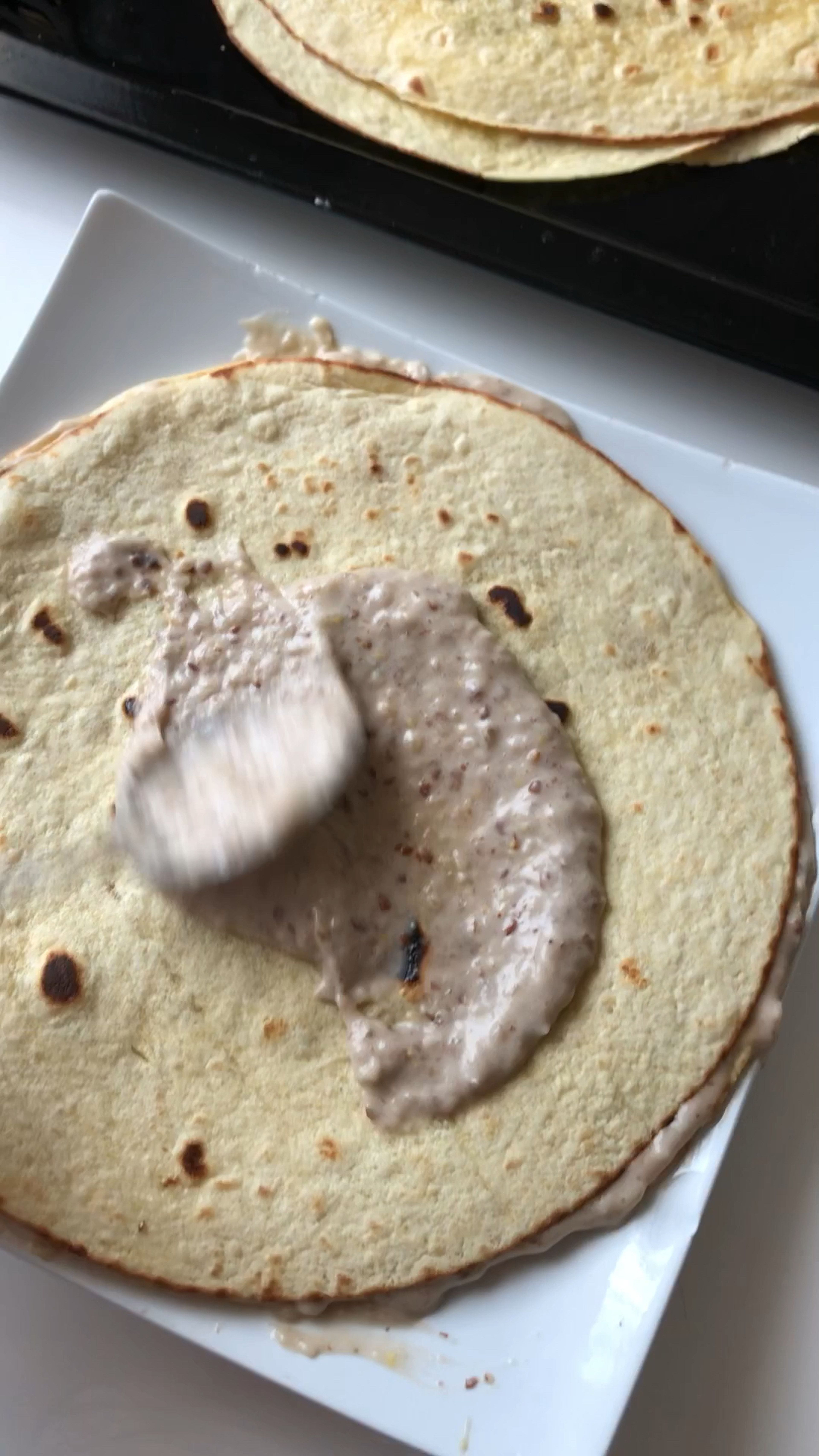 Lubricate each tortilla leaf with the resulting cream, distributing it evenly.