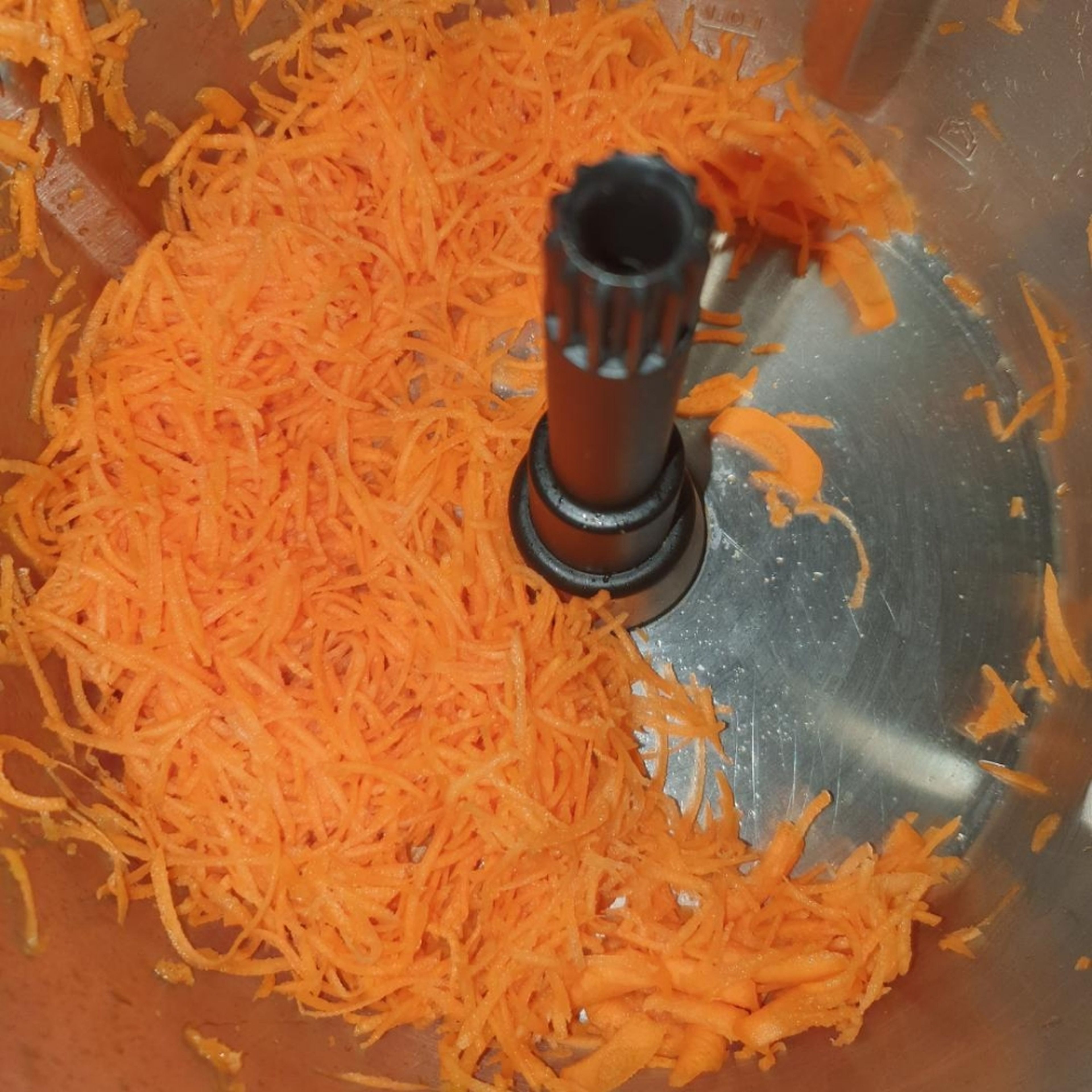 Putenbrust in ca 2 cm große Stücke schneiden und beiseite stellen. Karotten schälen. Den Zerkleinerungsaufsatz mit der Wenderaspelscheibe, feine Seite nach oben, einsetzen. Den Deckel schließen und Möhren fein reiben (Zerkleinerungsaufsatz | Stufe 6). Geriebene Karotten aus dem Cookit nehmen.
