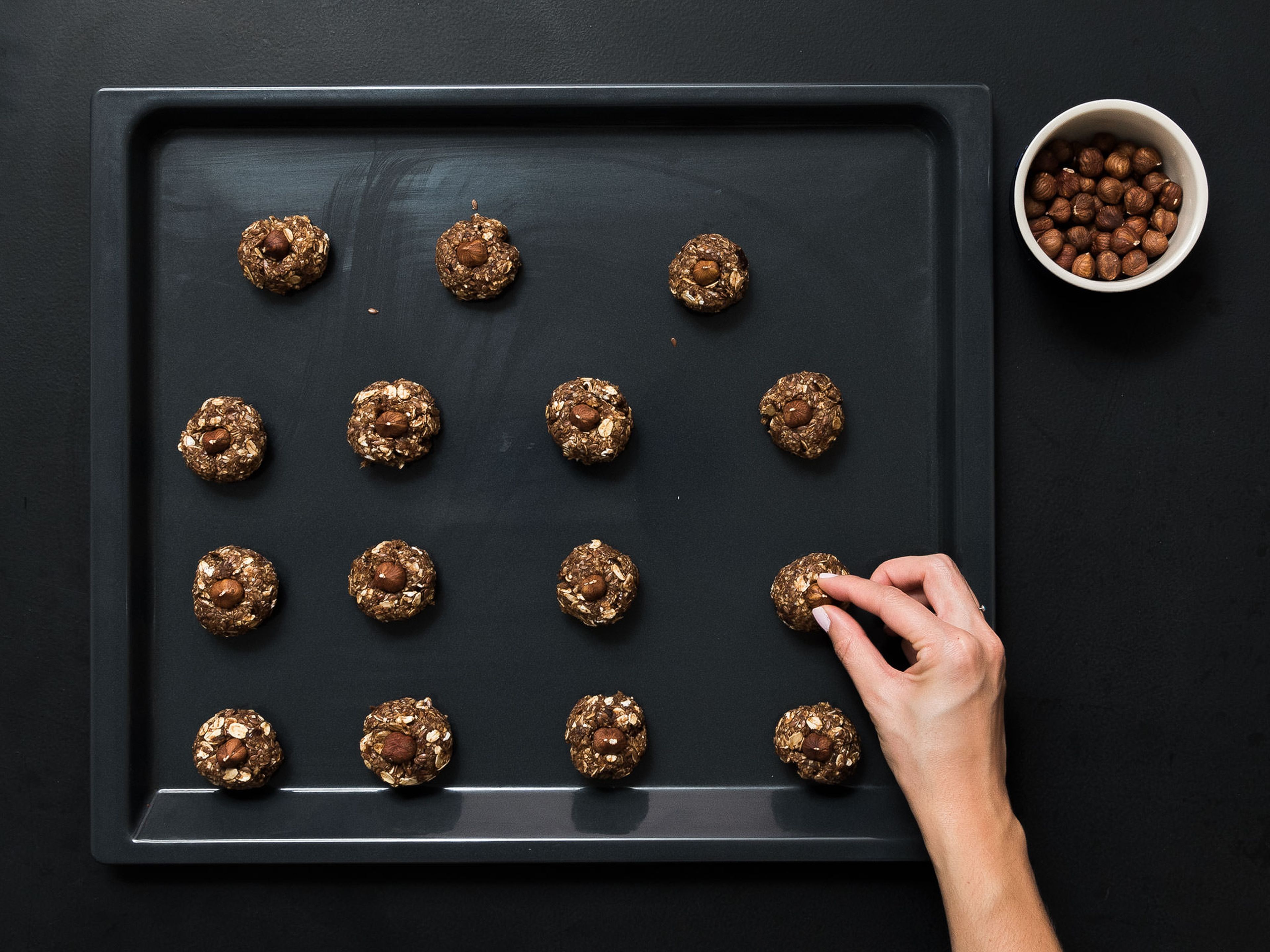 Form small balls of dough and place on a parchment-lined baking sheet. Lightly press 1 hazelnut into the top of each ball. Place in oven at 180°C/350°F and bake for approx. 15 min. Set aside to cool. Enjoy!