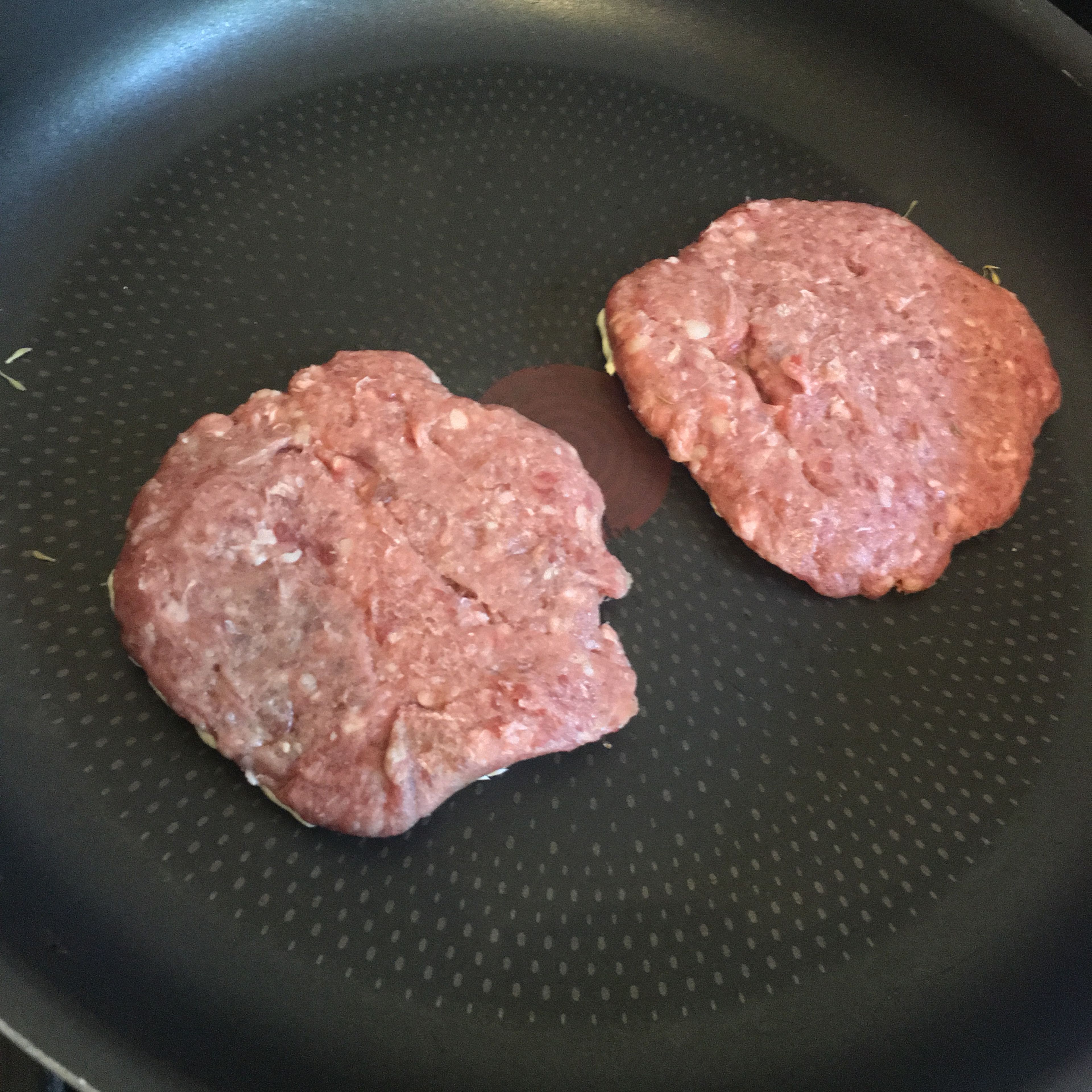 In a pan over high heat, put the burgers face down so the side with the butter on starts cooking first. Time these to cook for 5 minutes.