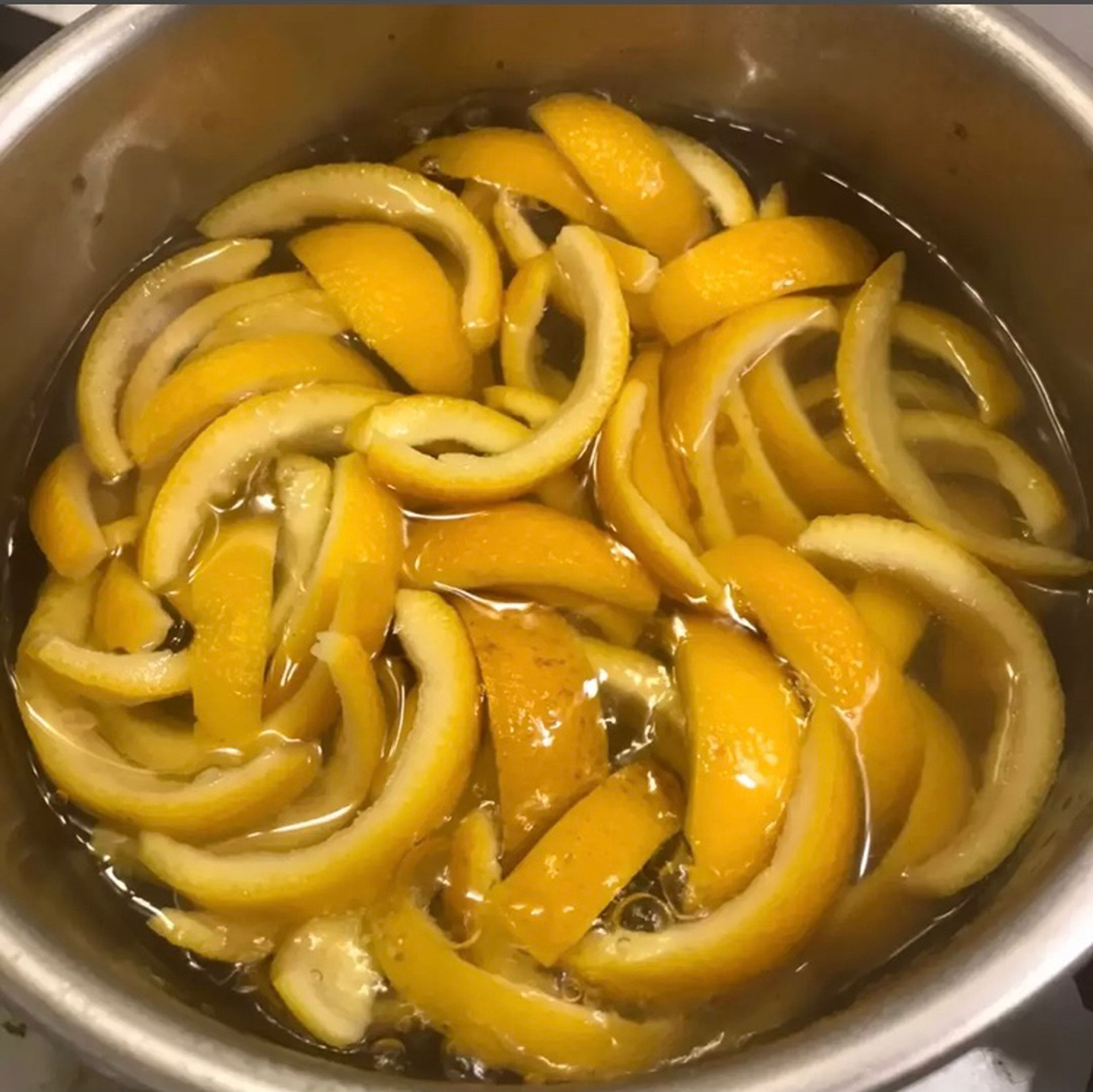Pour the slices into a little saucepan and pour 250ml cold water over it and put it on a medium flame until it boils. Then drain it and return it to the pot, pour cold water again and let it boil. Do this up to three times to remove the bitterness of the orange peel.