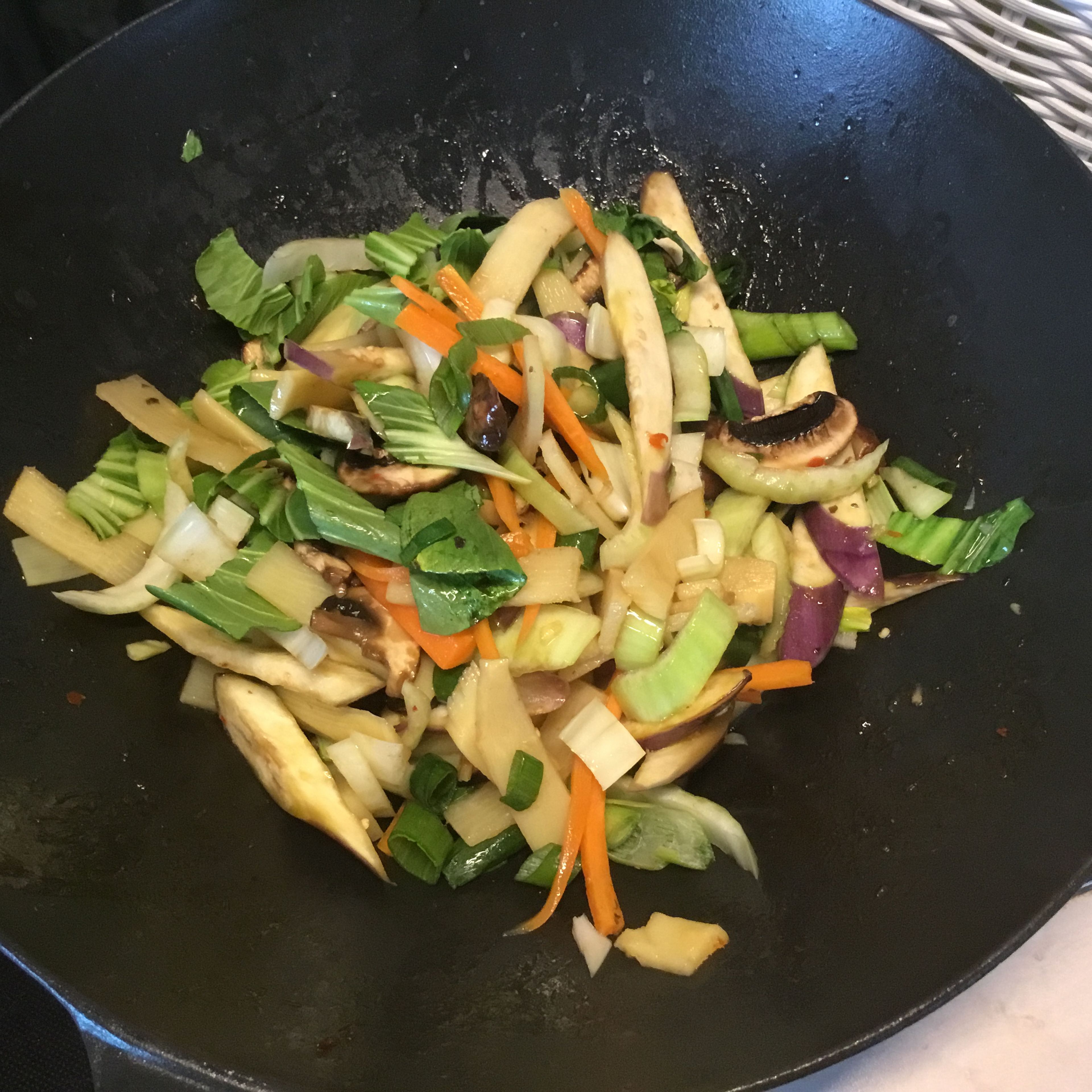 Das Chinagemüse im selben Wok zubereiten. Etwas Sesamöl erhitzen und erst die etwas länger dauernden Gemüseanteile ( hier Karotten und Stielanteile Pak Choi) kurz erhitzen. Danach das Restgemüse hinzufügen.