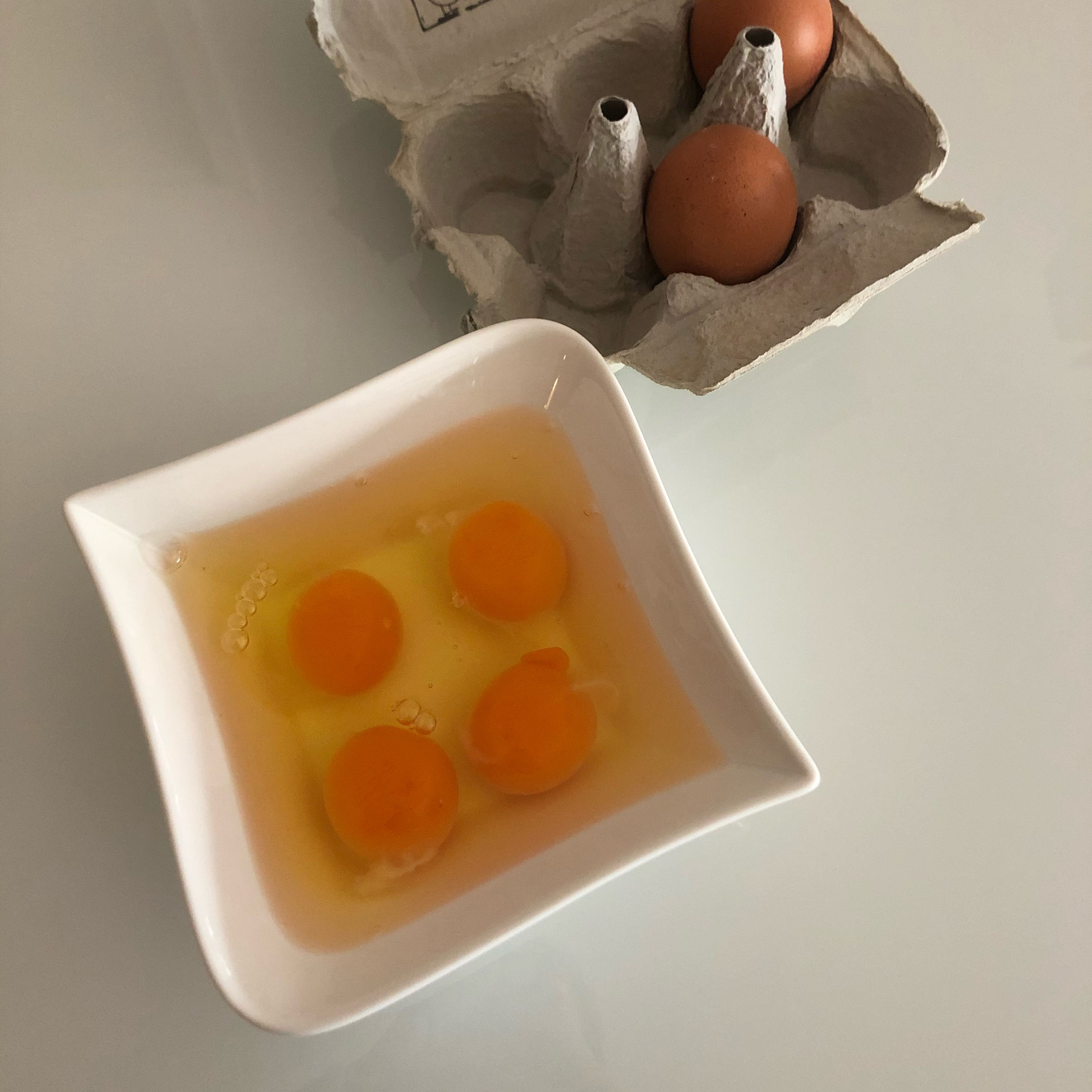 4 Eier in einer Schüssel aufschlagen