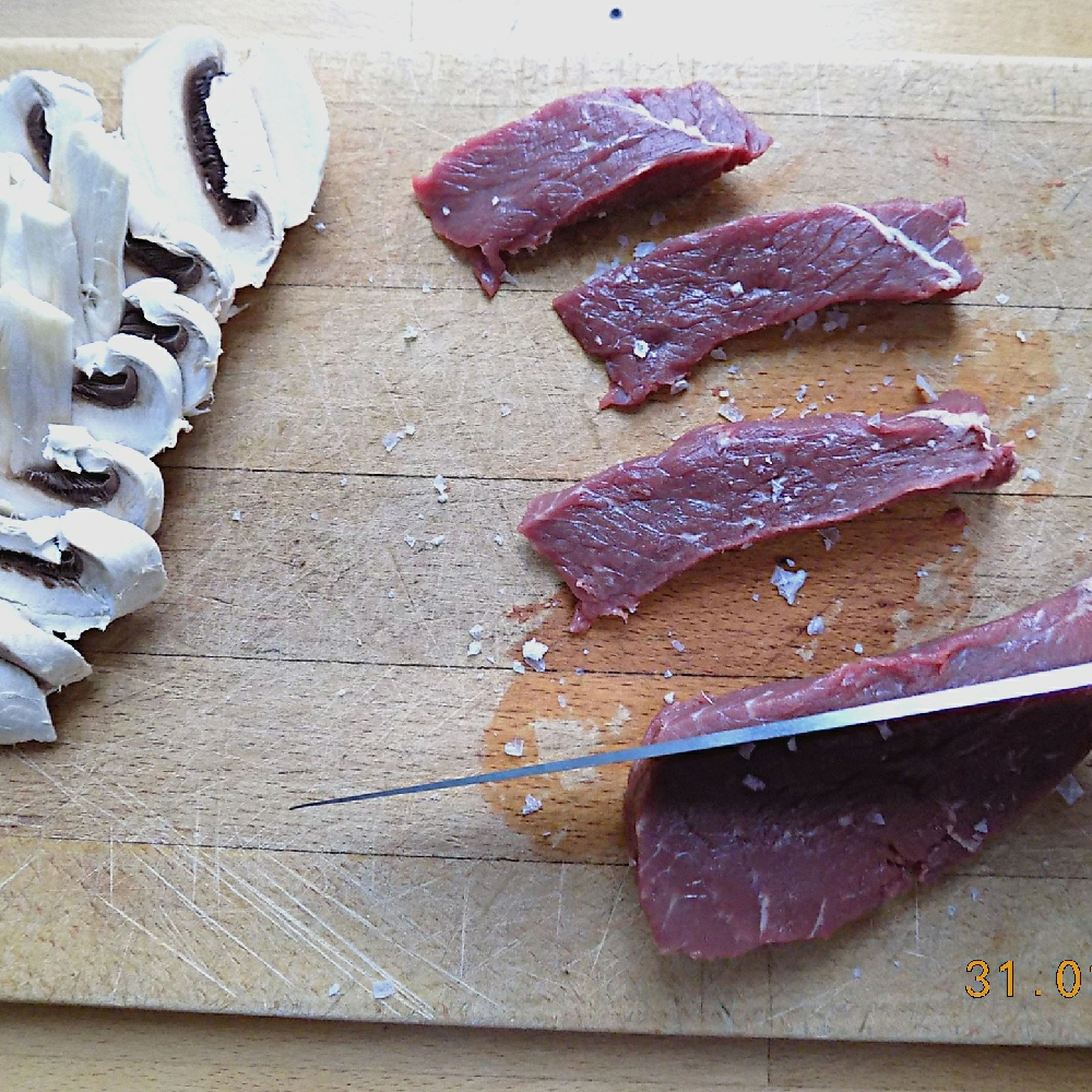 Slice the beef filet into strips and season with salt and pepper. Slice mushrooms.
