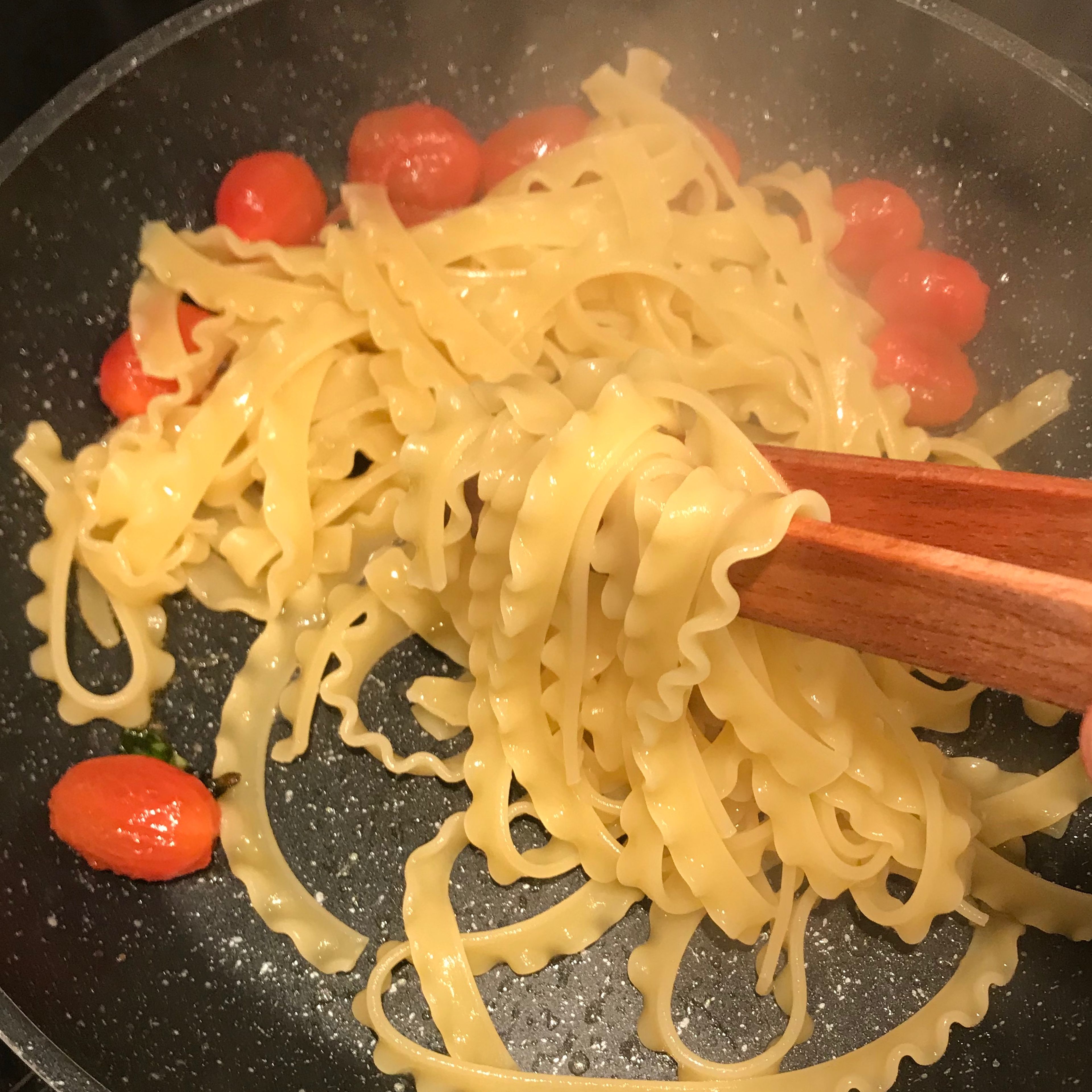 Remove the garlic and put the pasta in the pan with tomatoes. 