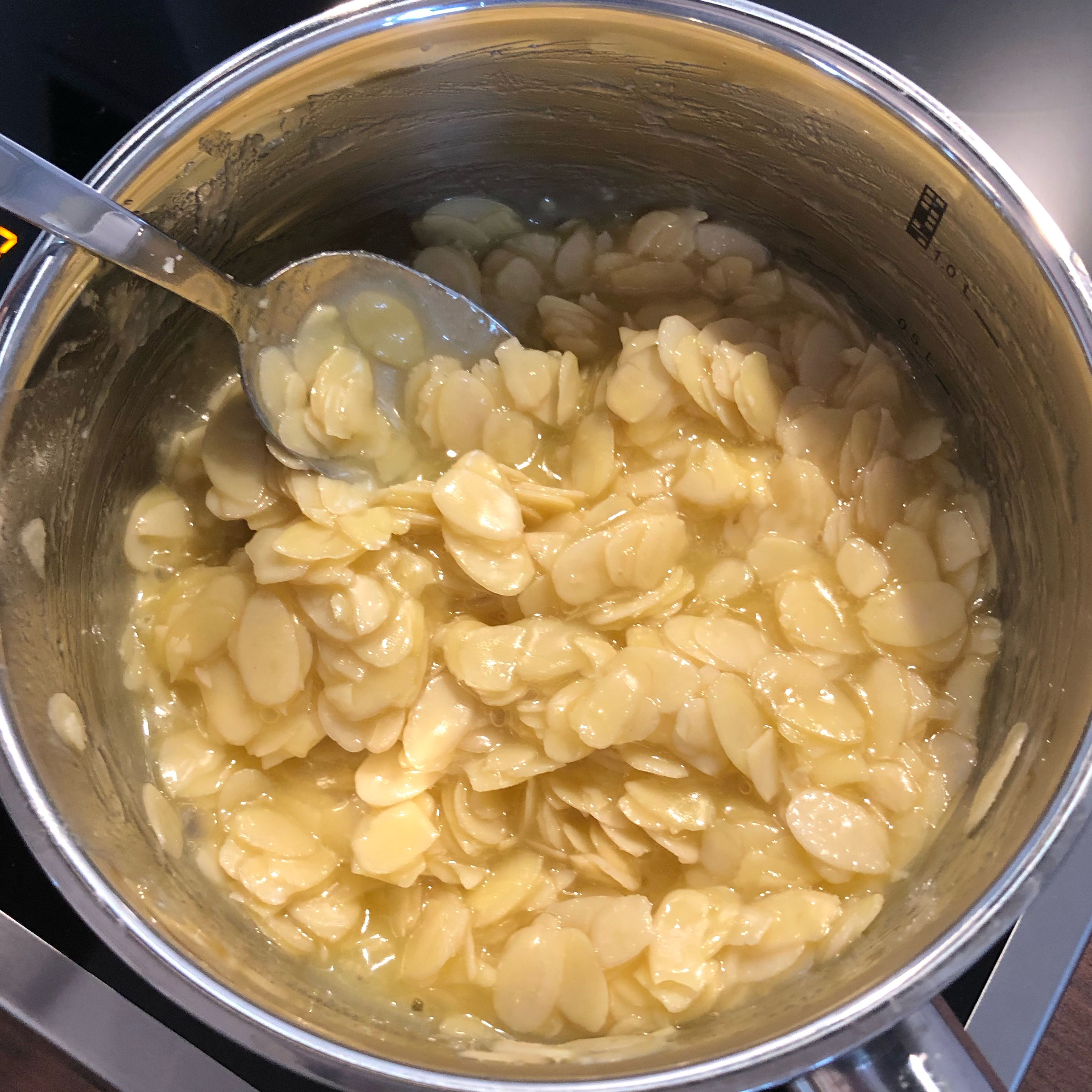 In der Zwischenzeit wird die Mandelmasse vorbereitet. Hierzu in einem Topf die Butter schmelzen. Zucker, Weizenmehl, Milch, gehobelte Mandeln und eine Prise Salz hinzufügen und unter stetigen Rühren für 10 Minuten köcheln lassen.
