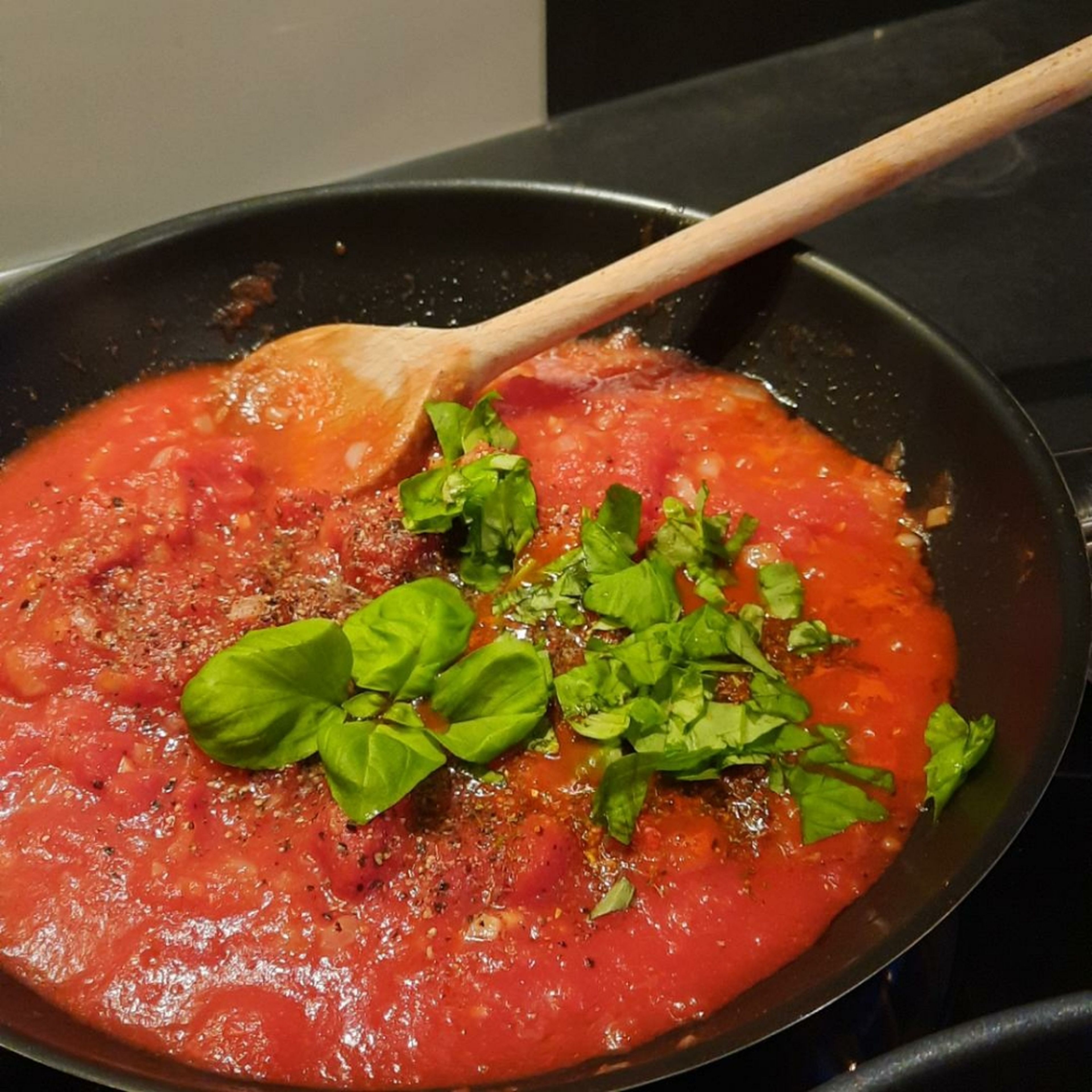 Die Tomatensoße nach Belieben würzen. Basilikum haken, zu der Soße geben und alles miteinander vermischen.