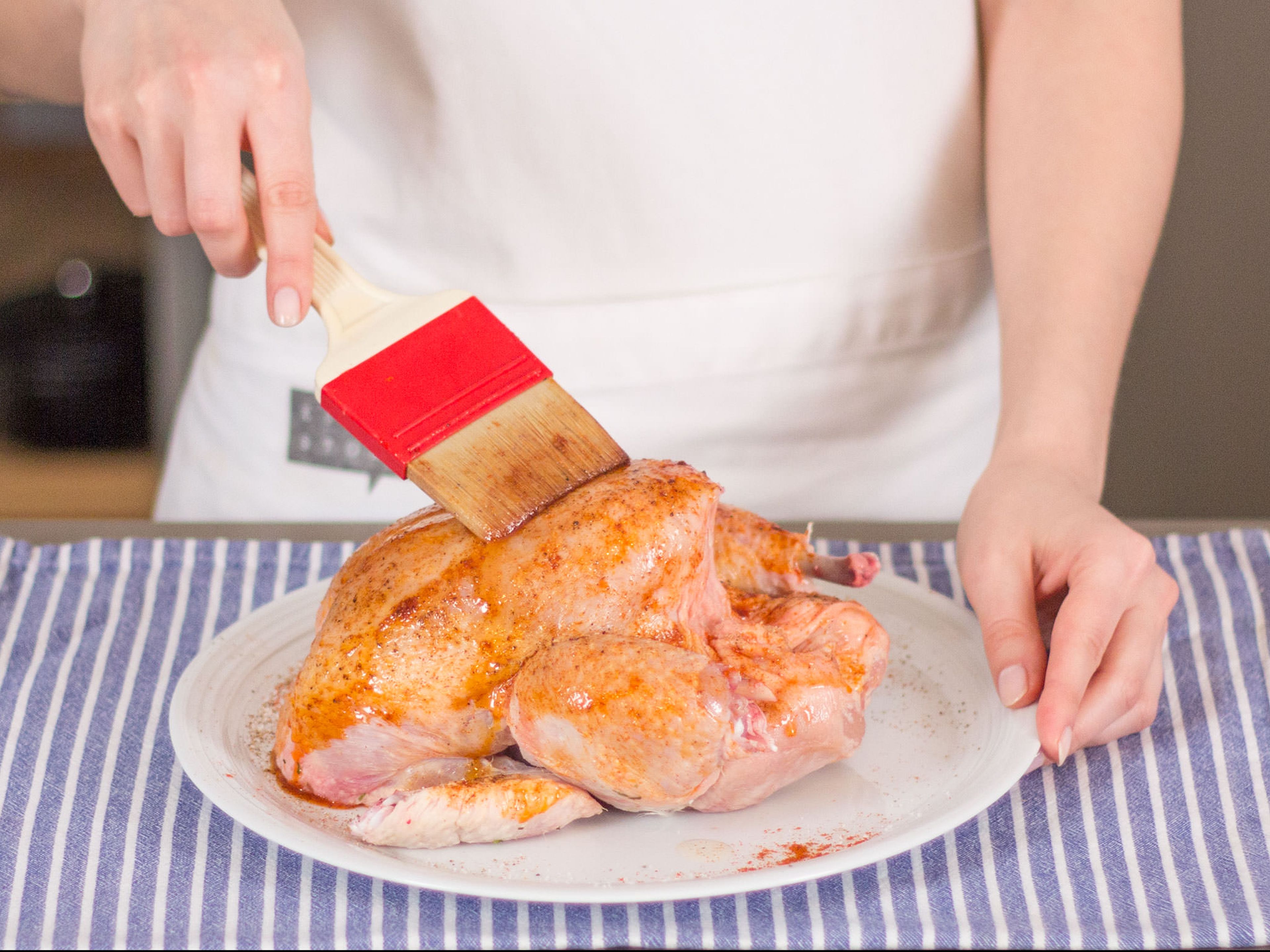 Remove neck and giblets from inner cavity of chicken. Brush with vegetable oil and season with salt, pepper, and paprika.