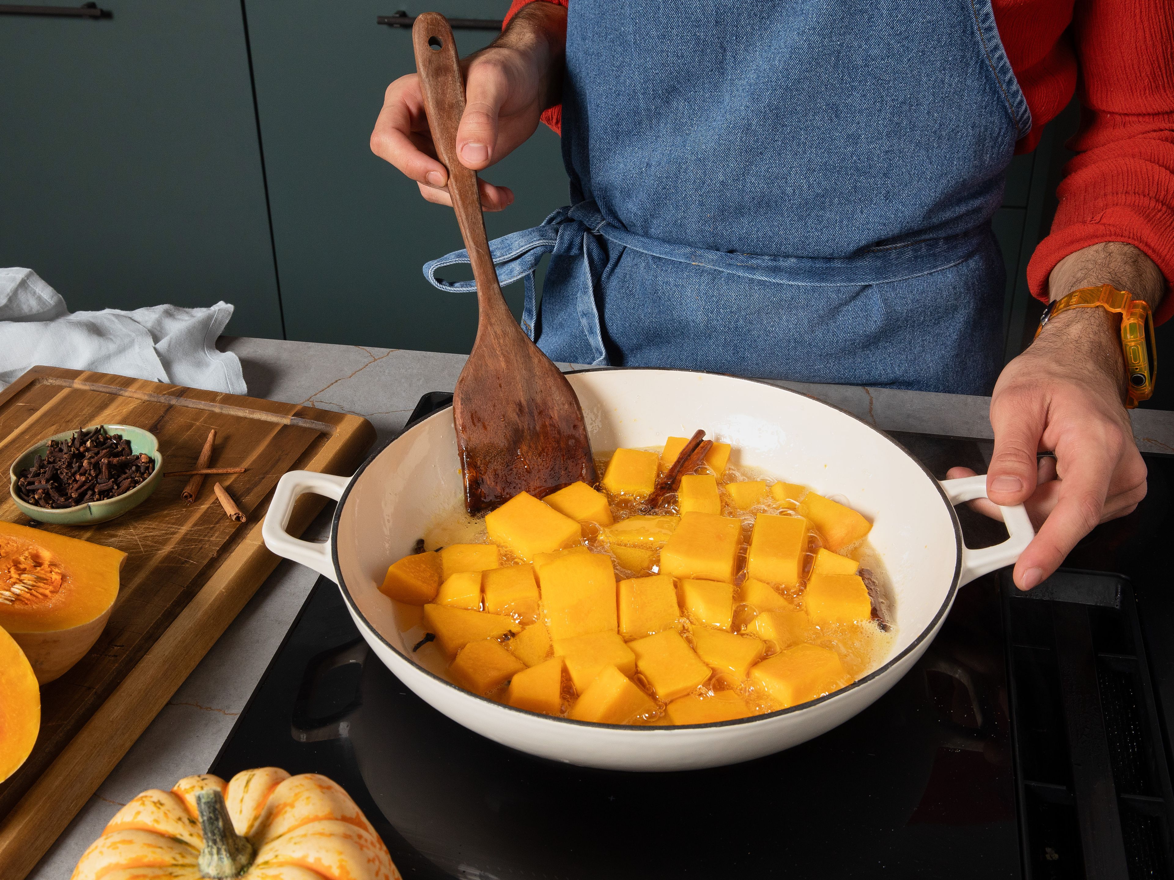 Nachdem der Zucker aufgelöst ist, Zimtstange und Nelken dazugeben. Dann alles bei mittlerer bis niedriger Hitze ca. 30–40 Min. köcheln lassen, bis die Kürbisstücke weich und zart sind. Gelegentlich umrühren, um ein Anbrennen des Zuckers zu vermeiden. Falls nicht genug Flüssigkeit vorhanden ist, ca. 1 EL Wasser pro Stück in den Topf geben.