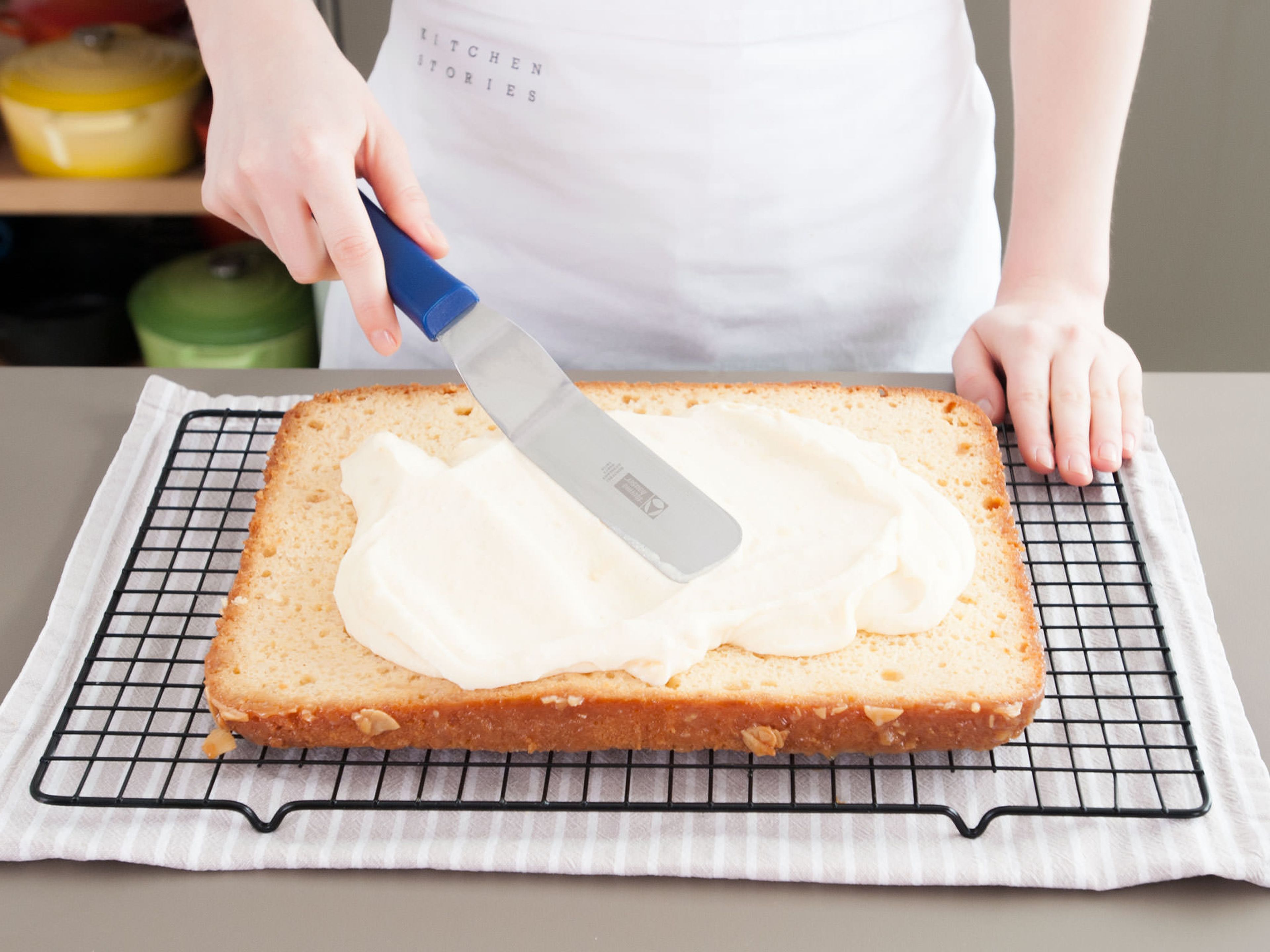 Den ausgekühlten Kuchen mit einem Brotmesser horizontal durchschneiden. Die Cremefüllung gleichmäßig auf der unteren Hälfte des Kuchens verstreichen.