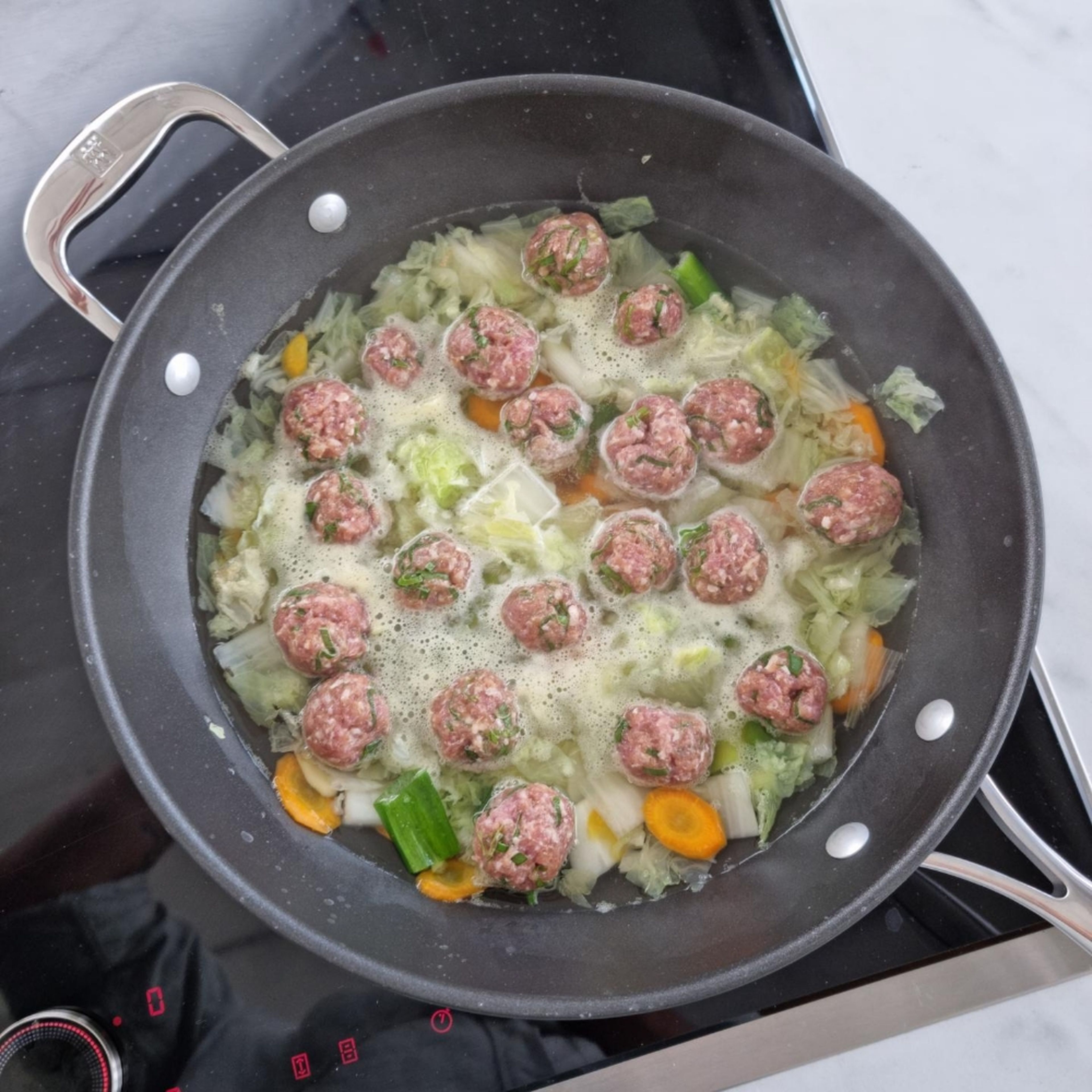 Carefully drop the meatballs one by one into the boiling soup and let simmer for about 5 min.