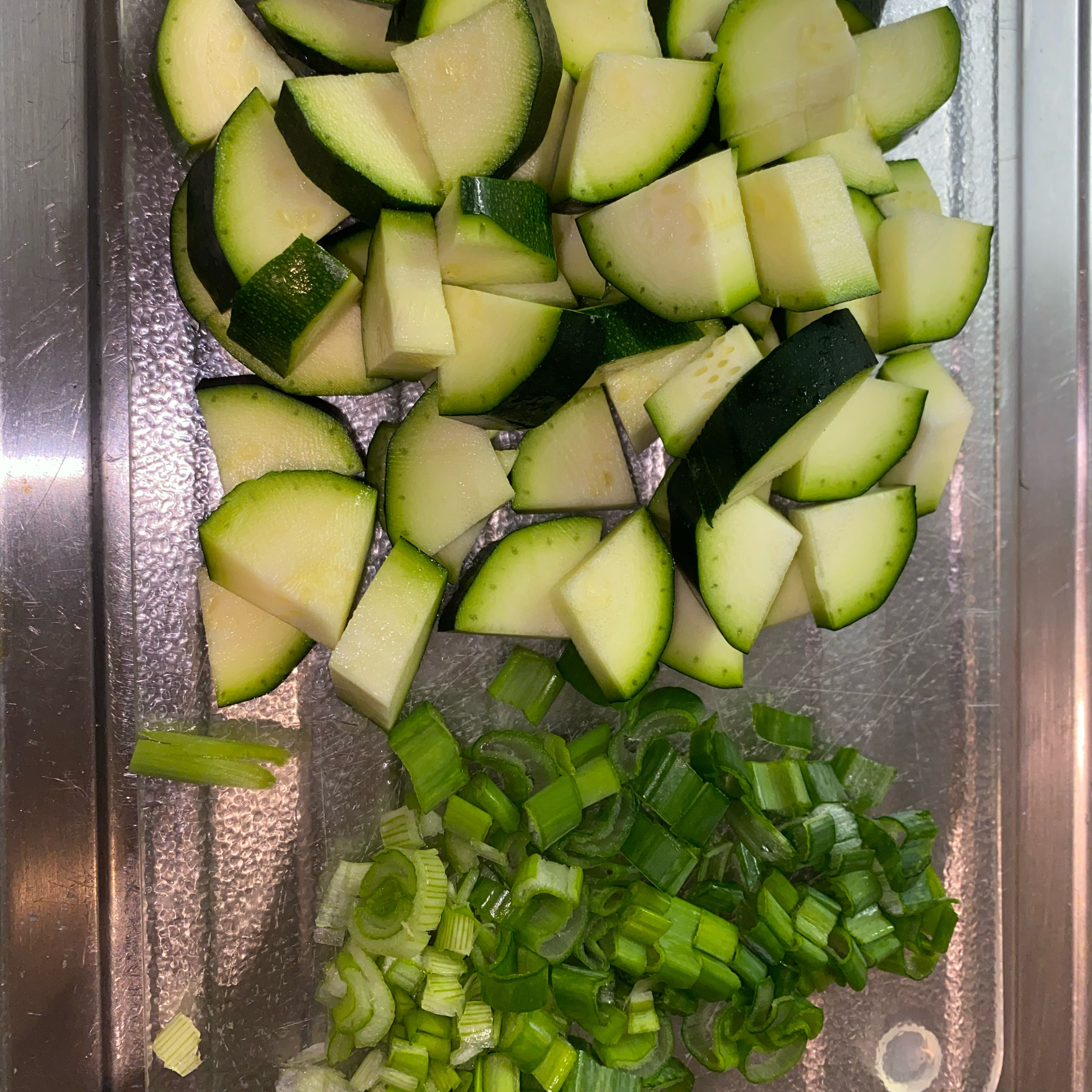 In dieser Zeit die Zucchini und Frühlingszwiebel schneiden. Öl in einer Bratpfanne erhitzen und Zwiebelpulver bis goldbraun anbraten. Nun die Zucchini beigeben und braten.