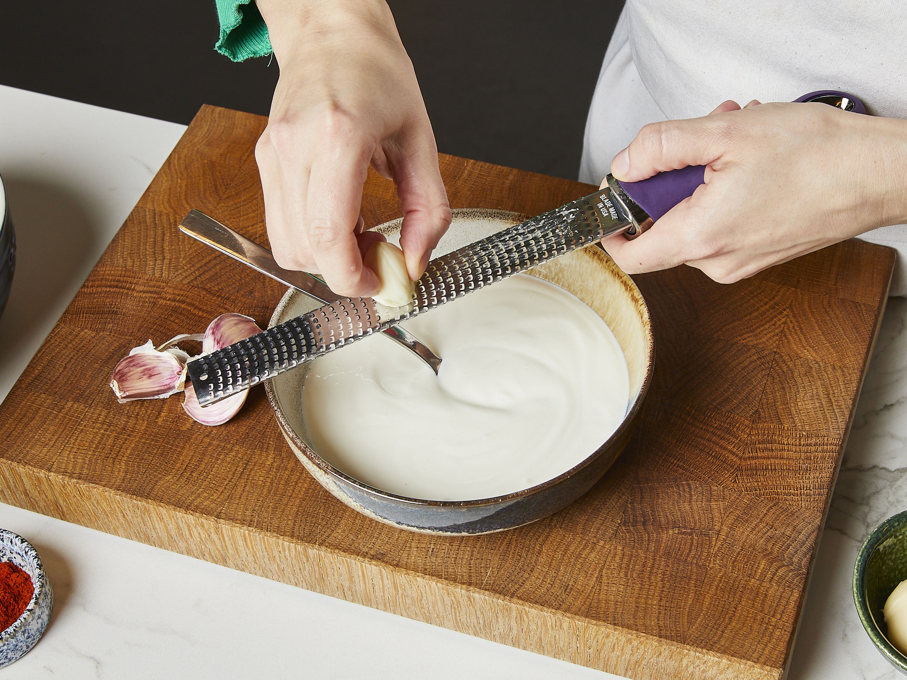 Joghurtalternative in eine Schüssel geben. Knoblauchzehen schälen und mit in die Schüssel reiben. Mit Salz würzen und vermischen. Die Pasta abgießen und warmhalten.