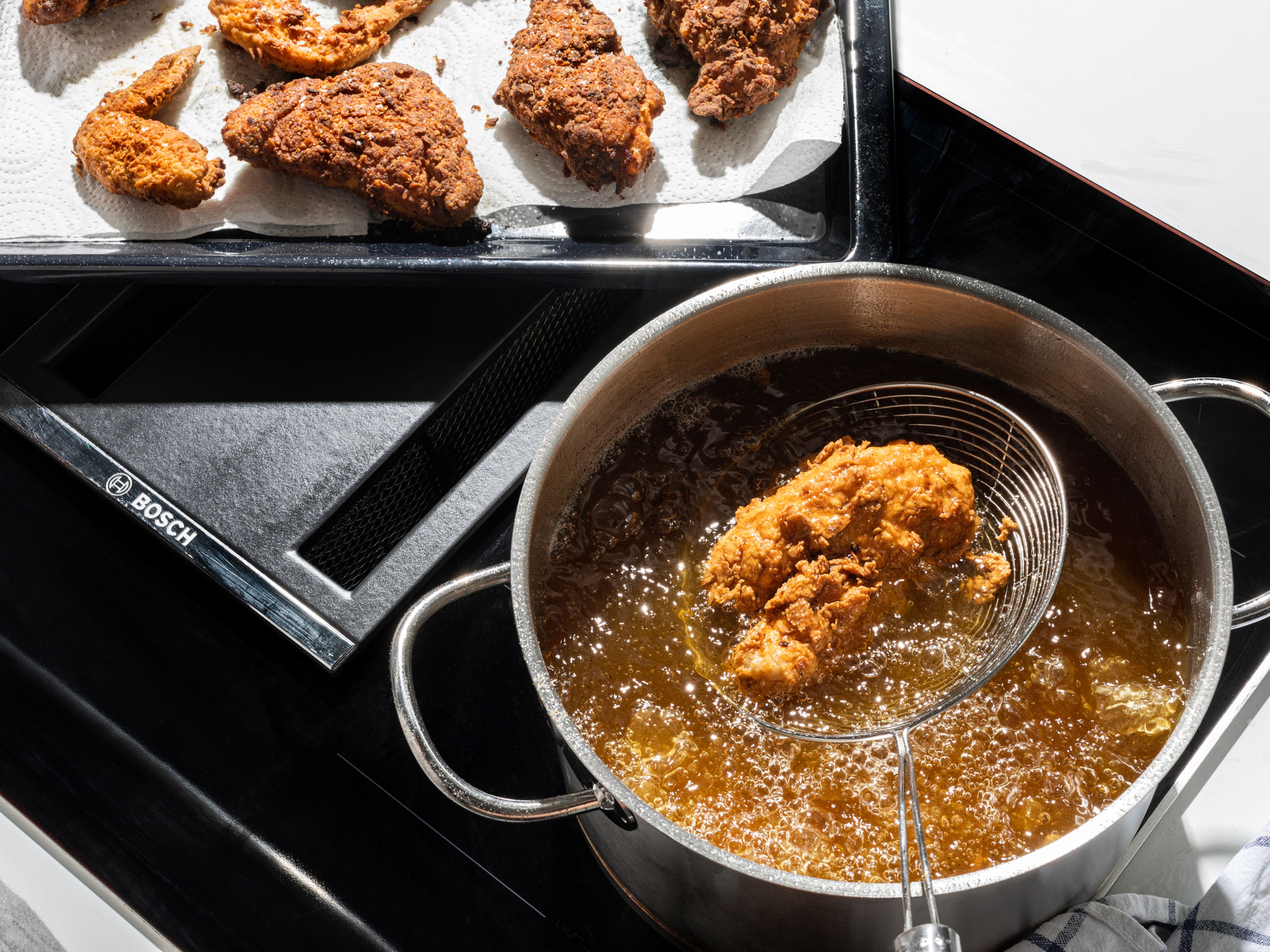 For the deep-fried method, heat up oil in a large stainless steel pot, over medium-high heat, until it reads 175°C/345°F on a thermometer. Safely lower approx. 3 pieces of chicken into the oil, one at a time, using tongs. Cook for approx. 10 – 14 min, until golden brown and cooked through. Gently stir the oil a couple of times during the cooking process to rotate the chicken. White meat like chicken breast takes less time to cook, and should register at least 71°C/160°F internally. Dark meat like thighs or any meat on the bone should register 74°C/165°F. To test, lift a piece of chicken out of the oil using a slotted spoon or tongs and pierce with the meat thermometer. Remove the chicken from the pot and let drain on a wire rack. Continue with all remaining chicken.