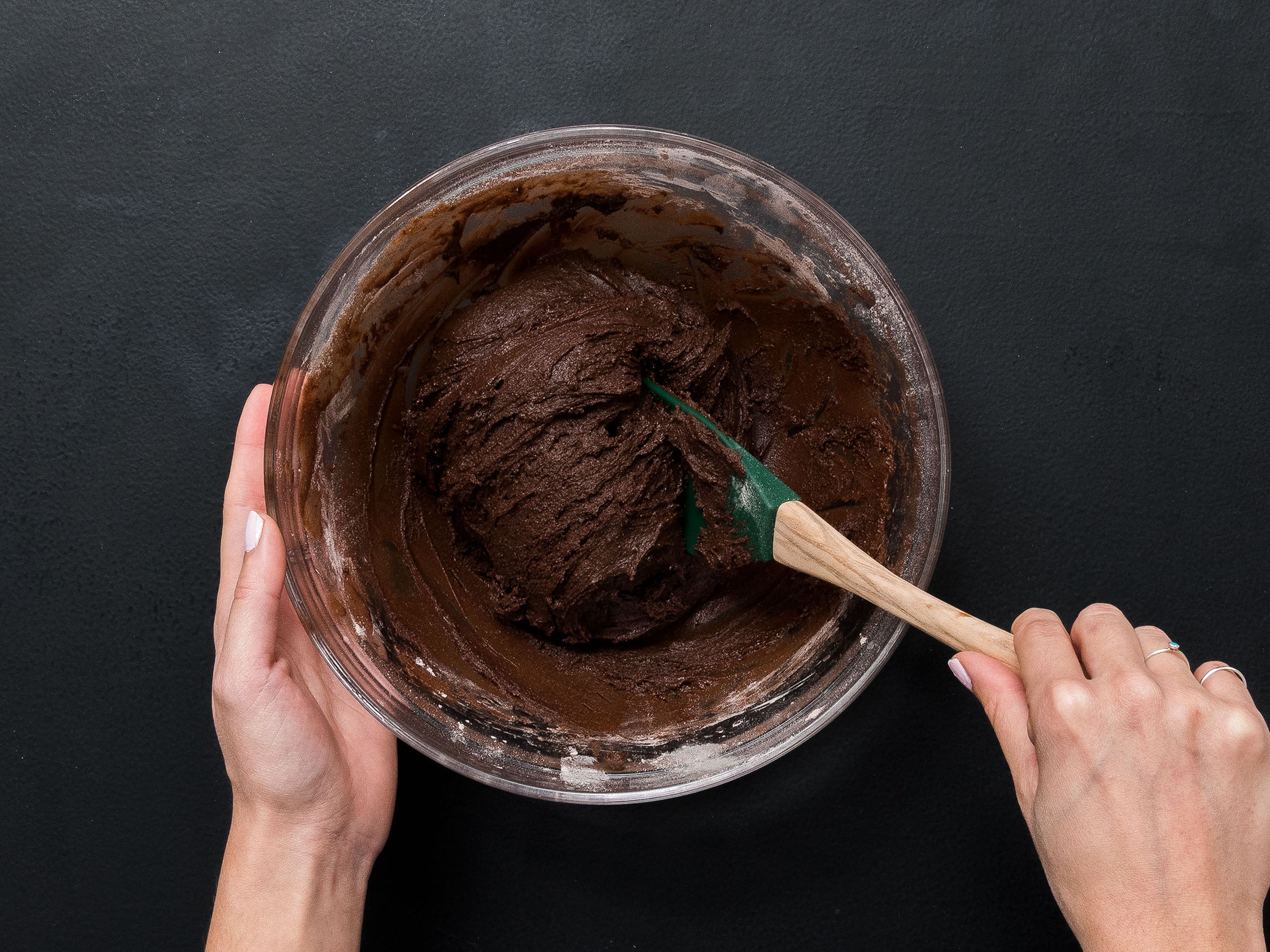 Schokoladen-Butter-Mischung zugeben und gut umrühren. Die trockenen Zutaten nach und nach zugeben und alles zu einem festen Teig formen.