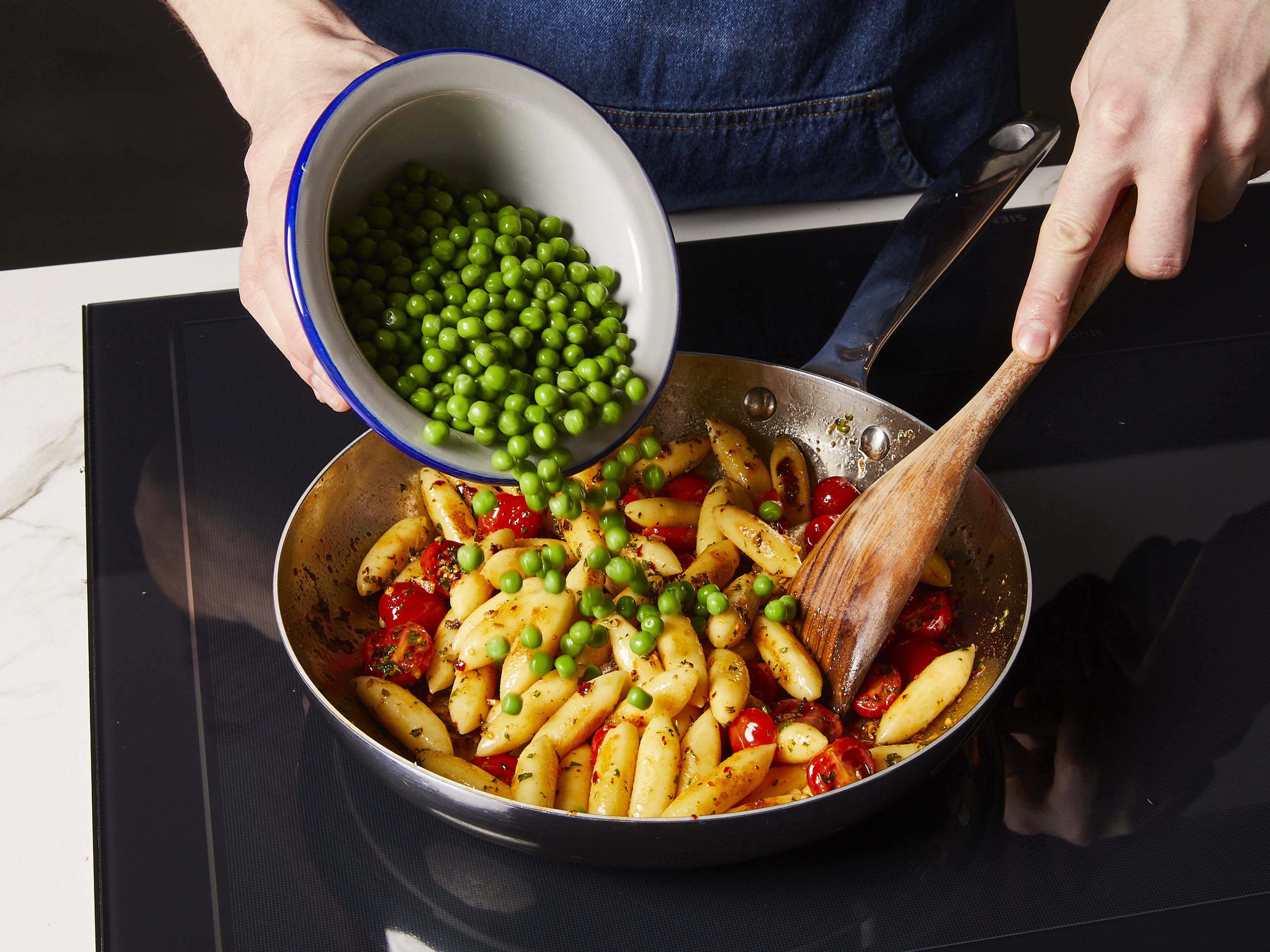 Add in the German gnocchi, cherry tomatoes, and peas. Sauté for 2–3 min. until tomatoes are slightly soft. Serve with parmesan to your liking on top.