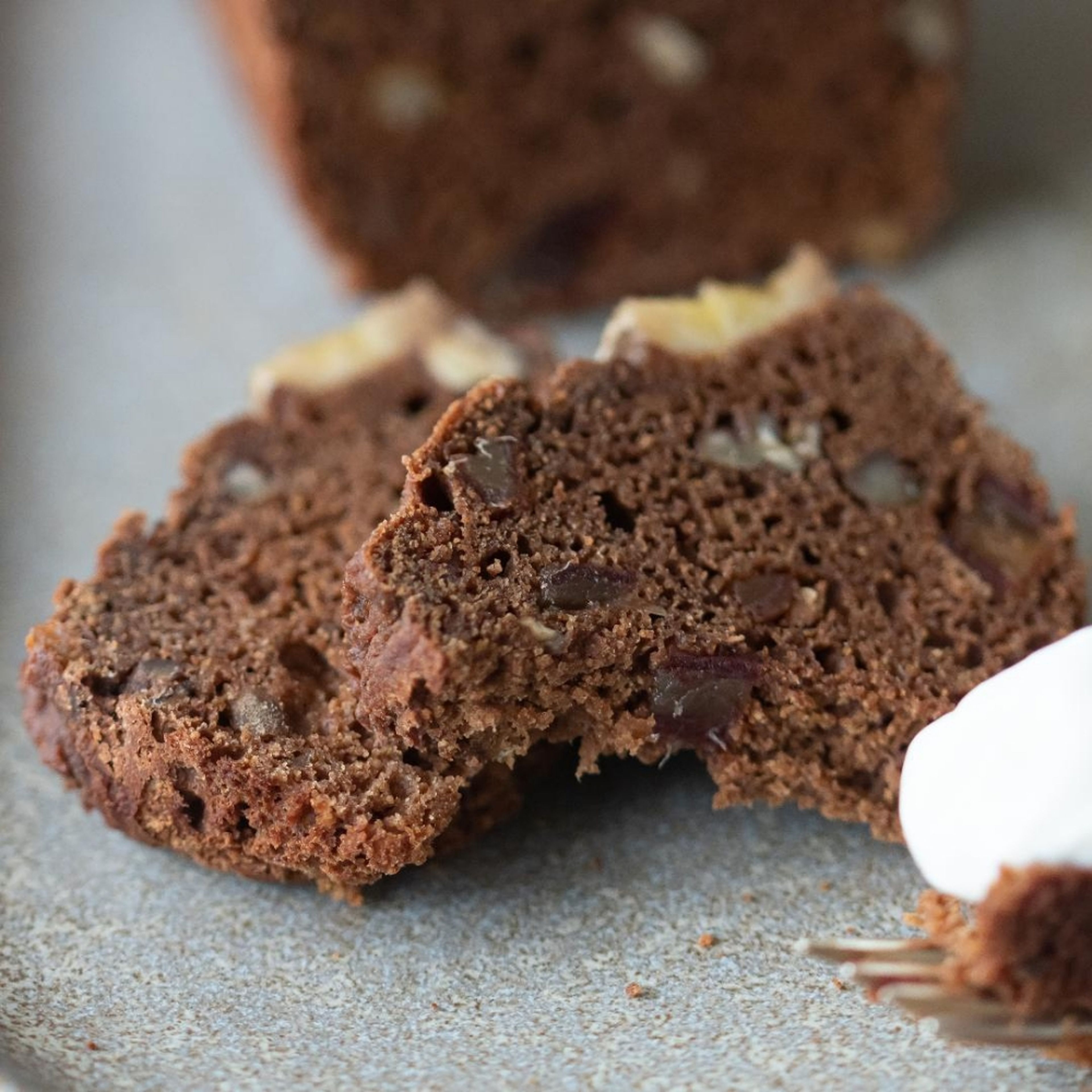 Eine Banane mit einer Gabel zerdrücken, die Nüsse hacken und mit den restlichen Zutaten (außer der 2. Banane) zu einem geschmeidigen Teig verrühren. Die Backformen mit Backpapier auslegen und den Teig einfüllen. Die übrige Banane der Länge nach in dünne Scheiben schneiden und auf den Kuchenteig legen und leicht eindrücken. Bei 180°C ca. 35 Minuten backen (ein großer Kuchen braucht ca. 60 Minuten). Gegebenenfalls das Bananenbrot nach einiger Zeit mit Backpapier abdecken, damit es nicht zu röstig