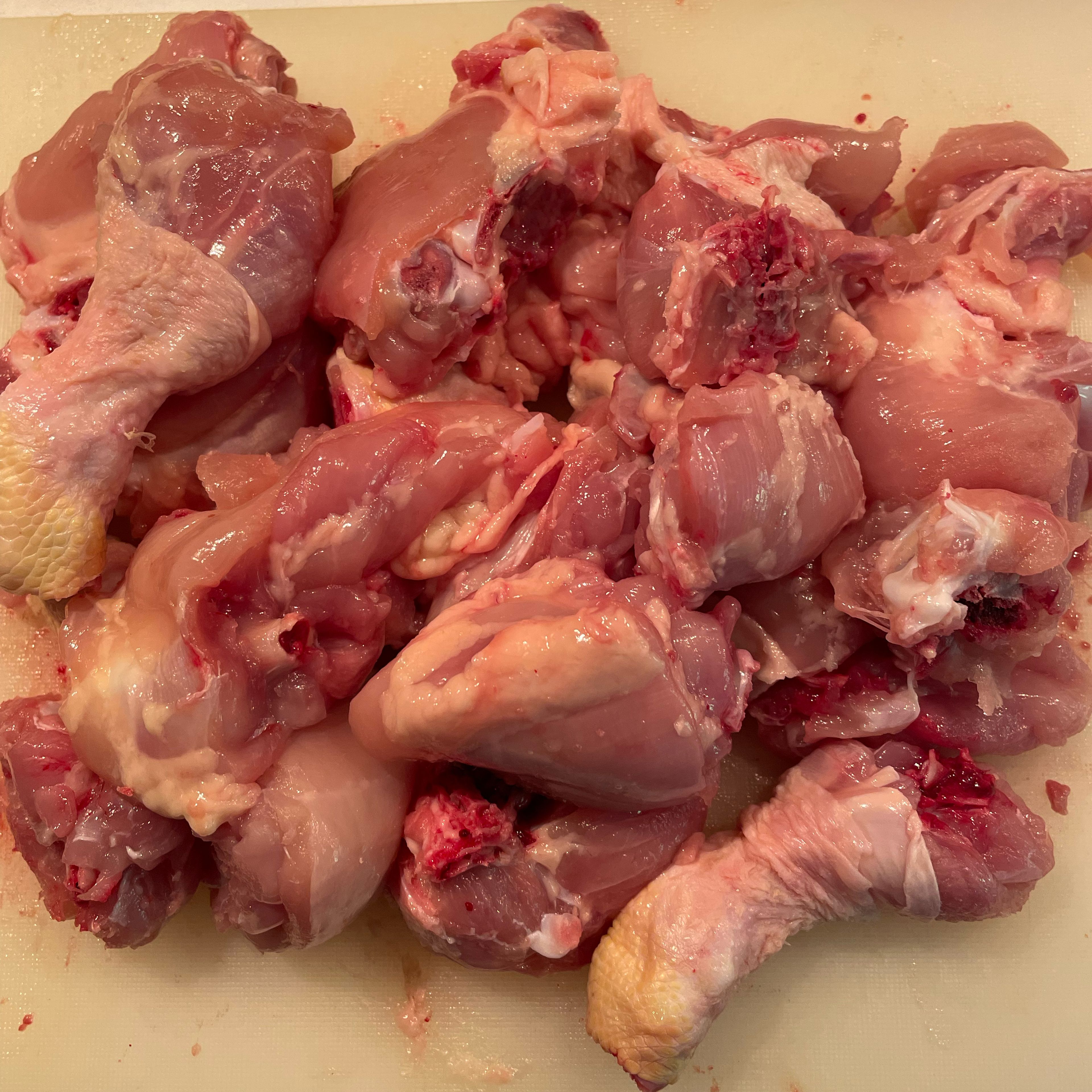 Remove excess skin and cut chicken into pieces, bones in.