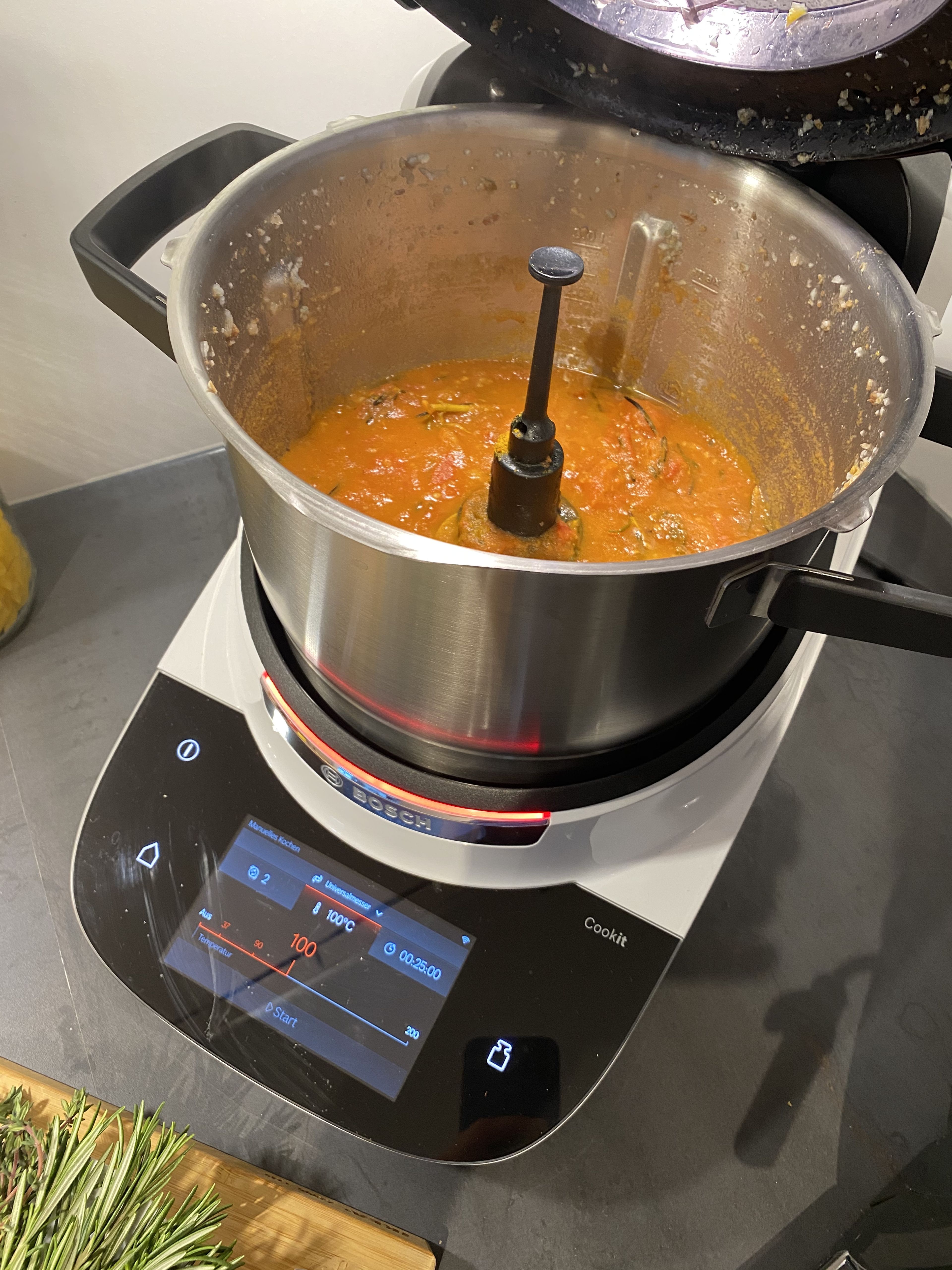 Nach Ende der Zeit sollten die Tomaten eine weiche Konsistenz haben. Sollte die Salsa zu flüssig sein, kann die Kochzeit um weitere 15 Minuten verlängert werden, jedoch ohne Messbechereinsatz, sodass die Feuchtigkeit entweichen kann.
Danach die Thymian- und Rosmarinzweige entfernen und die restlichen Zutaten (bis auf Hüttenkäse und Brot) hinzugeben.