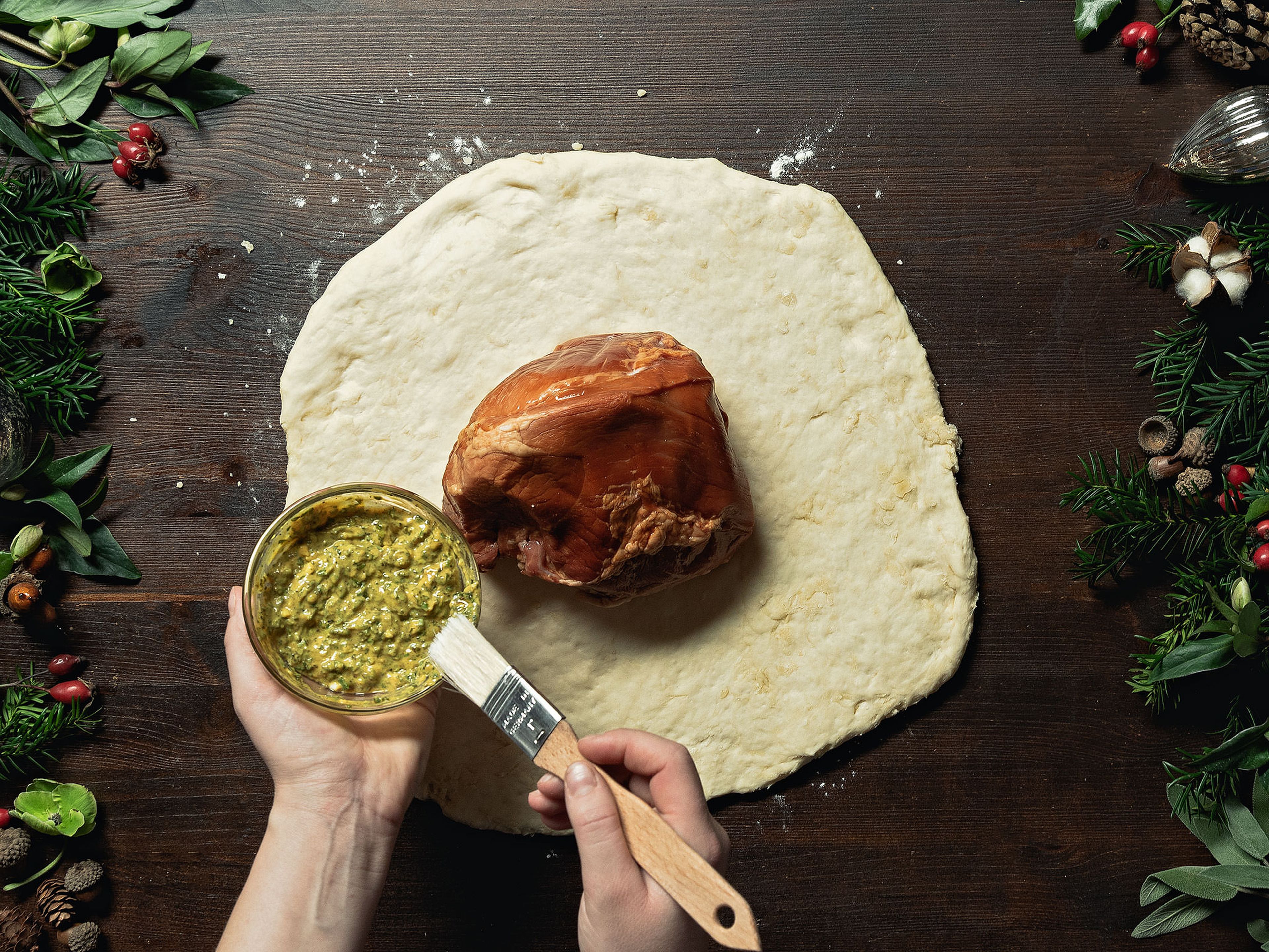 Preheat the oven to 165°C/325°F. Roll out the bread dough on a floured work surface. Put the ham on top and brush with the mustard-herb mixture. Use a bench scraper to help you wrap the ham in the dough. Place on a parchment paper-lined baking sheet and let rest for approx. 30 min., then bake for approx. 40 min.