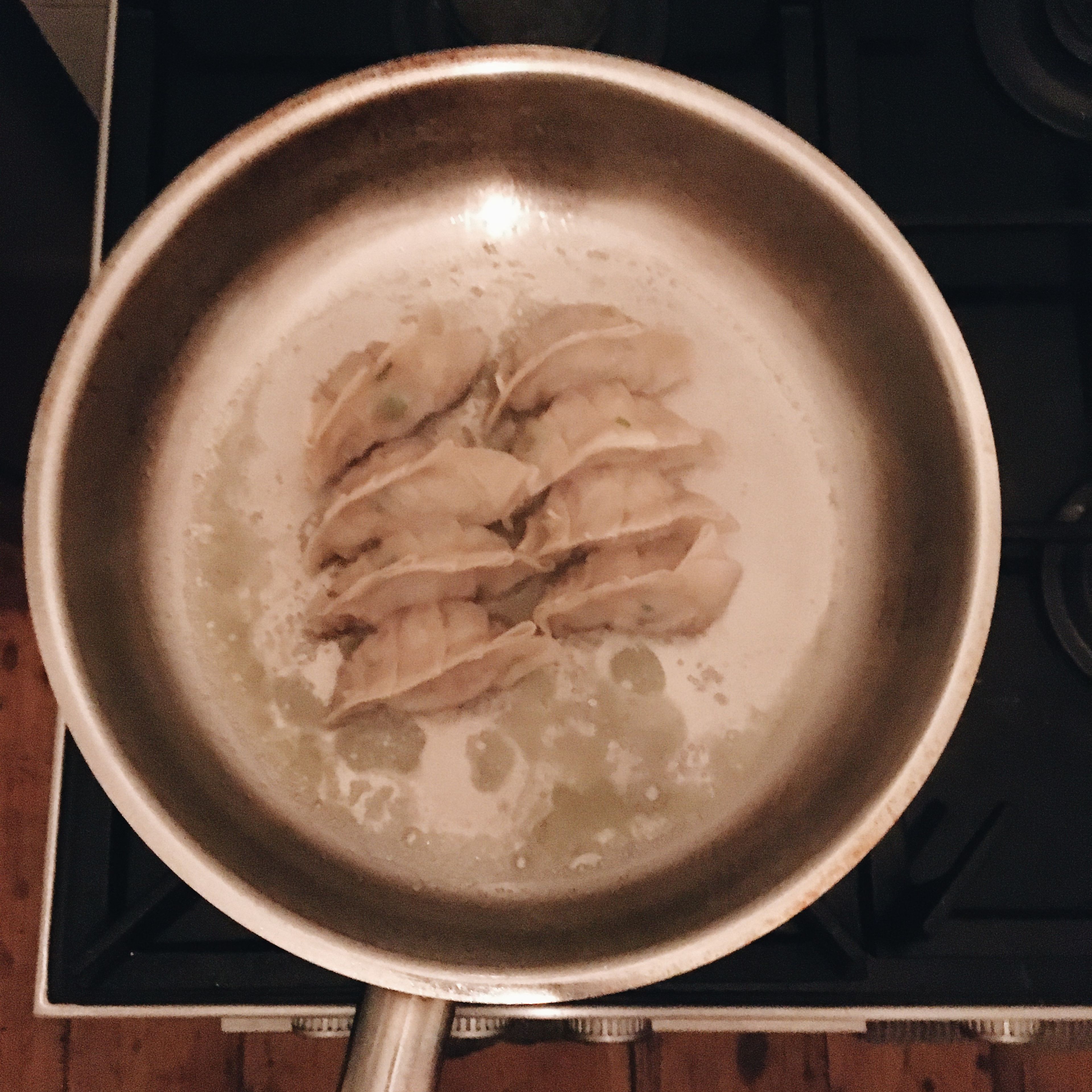 Pour water into the pan around the gyoza and place a lid. Steam the gyoza until the water is evaporated, roughly 5 min.
