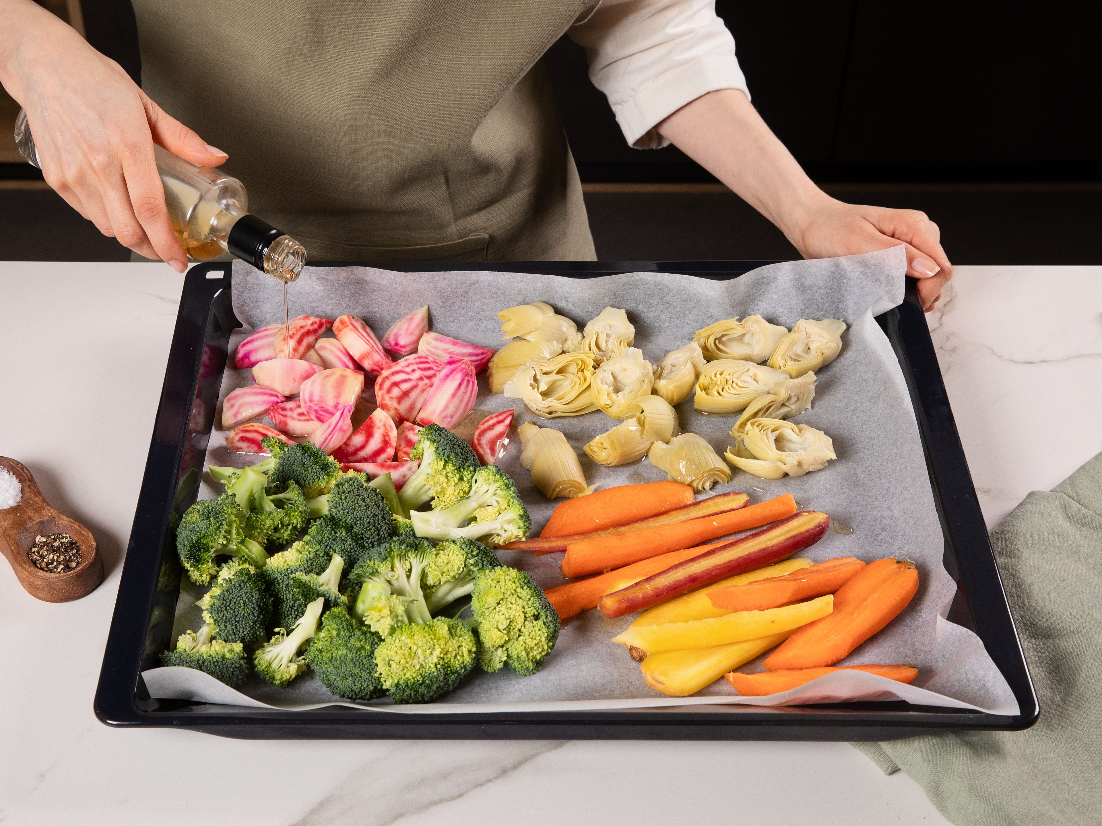 Den Ofen auf 220°C Ober-/Unterhitze vorheizen. Die Karotten schälen und vierteln, die Bunte Beete schälen und in ca. 1 cm breite Spalten schneiden, den Brokkoli in kleine Röschen teilen und die Artischockenherzen halbieren. Das gesamte Gemüse auf einem mit Backpapier ausgelegten Backblech verteilen. Mit enerBio Sesamöl geröstet beträufeln, mit Salz und enerBiO Pfeffer würzen und gut vermengen. Das Gemüse für ca. 20-25 Min. im Ofen rösten, bis es weich genug und an den Rändern leicht gebräunt ist.