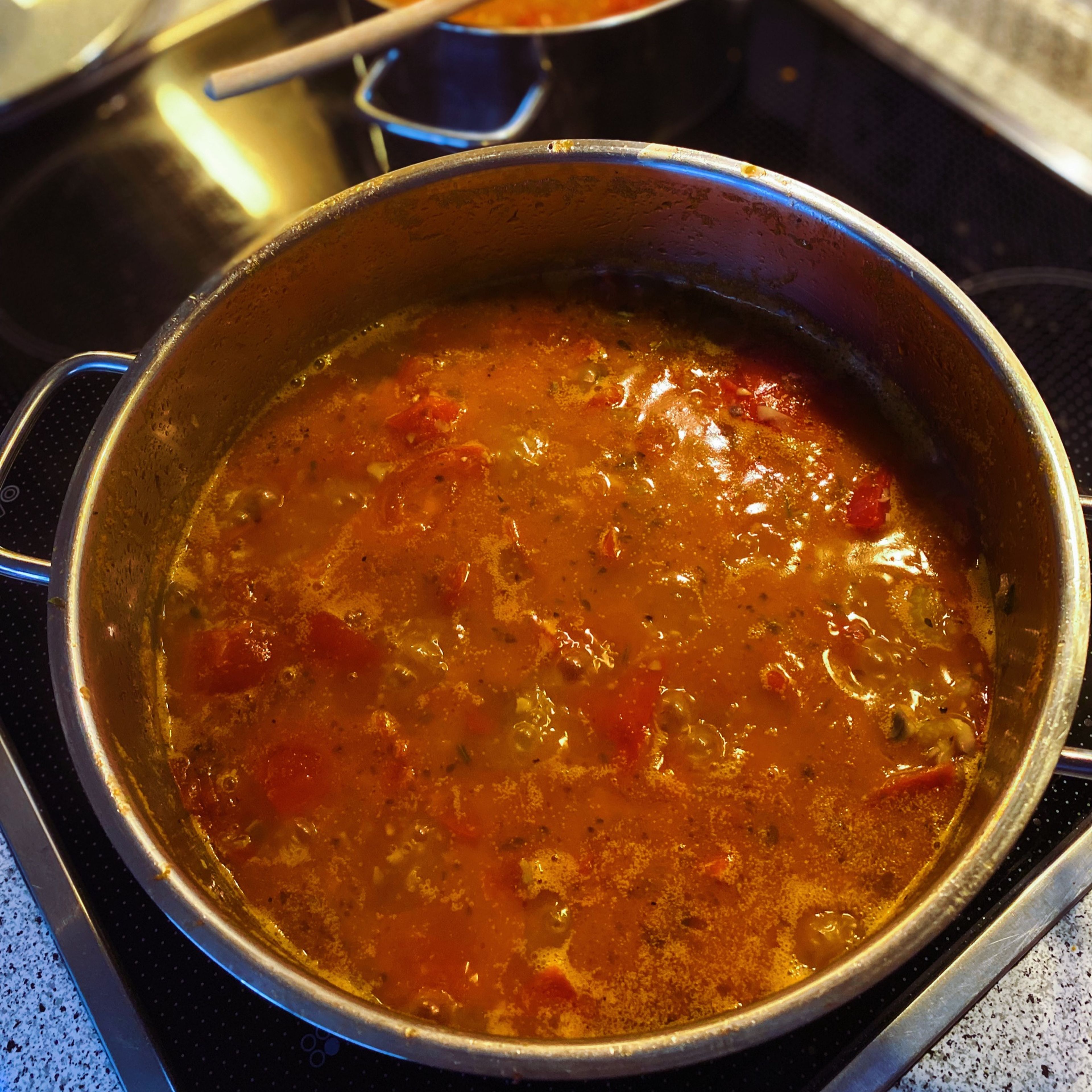 Die Tomaten und Kräuter hinzufügen. Das Sugo bei mittlerer Hitze 20min köcheln lassen, bis die Tomaten weich sind. Die Lorbeerblätter entfernen und alles passieren. Das Sugo mit Salz und Pfeffer würzen.