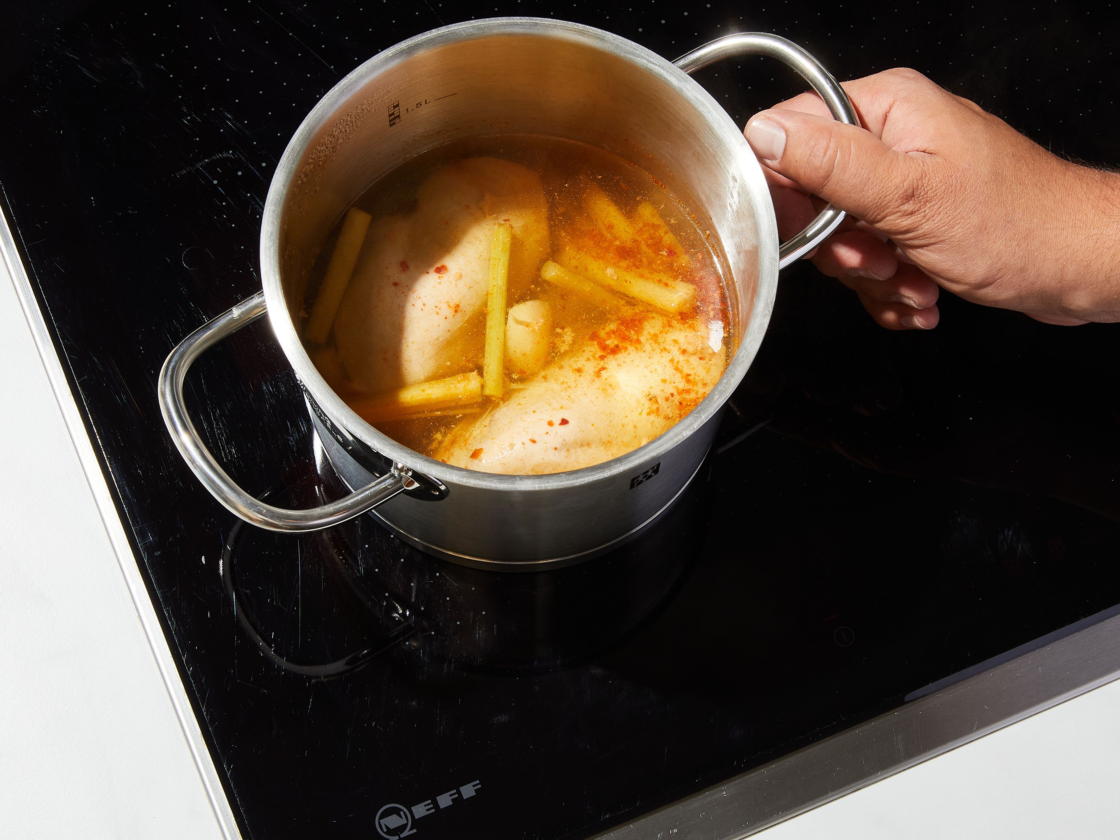 2 Stangen Zitronengras weichklopfen und in 3 cm lange Stücke schneiden. Wasser, Salz, Chiliflocken, die Hälfte des Knoblauchs, Zitronengras und das Hähnchen in einen Topf bei mittlerer Hitze geben. Zum Kochen bringen und anschließend die Hitze reduzieren. Bei geschlossenem Deckel ca. 20 Min. köcheln lassen, oder bis das Hähnchen gar ist. Das Hähnchen aus dem Topf nehmen und zum Abkühlen beiseite stellen.