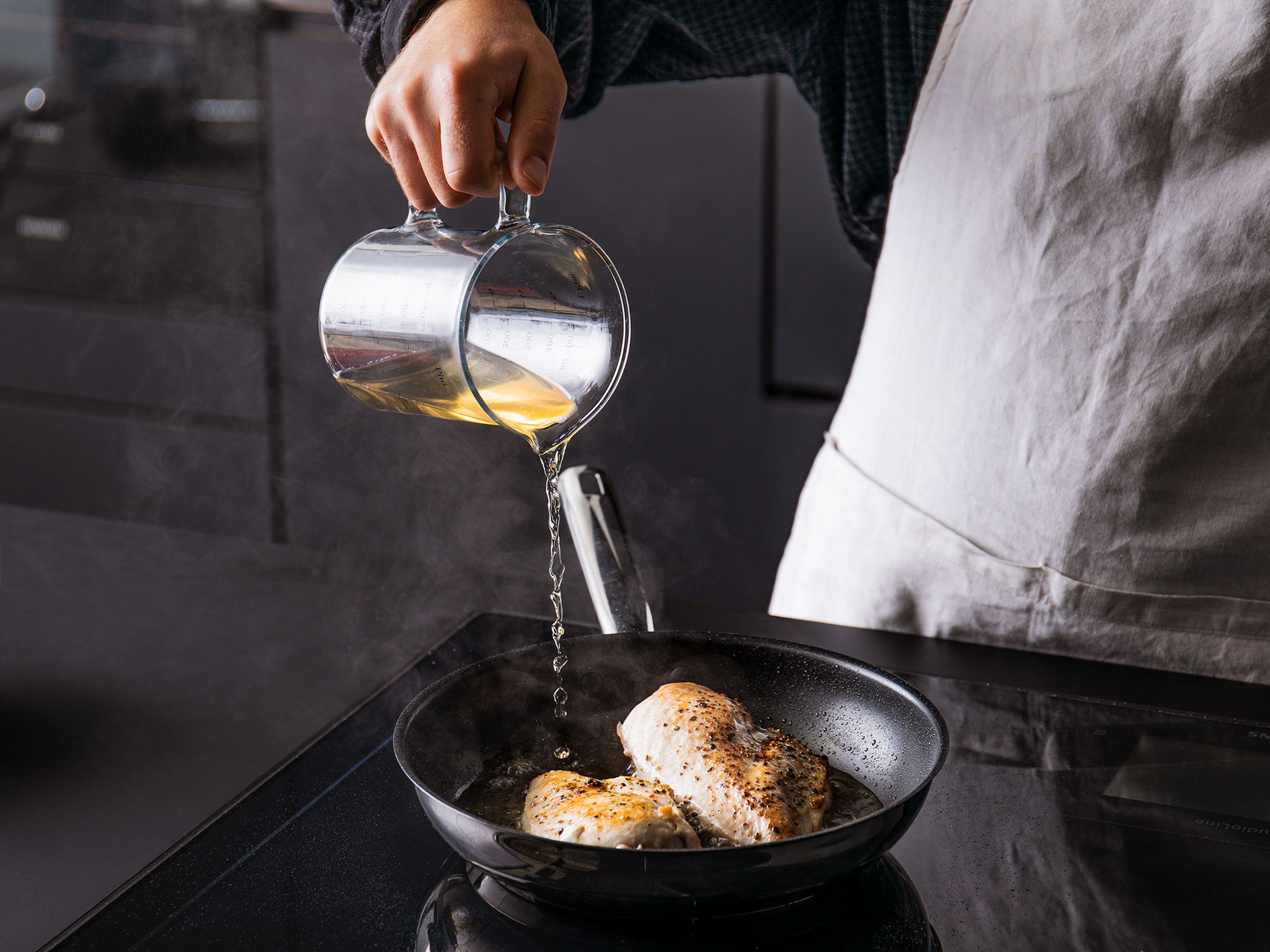 Die Hühnerbrust auf beiden Seiten mit Salz und Pfeffer würzen. Anschließend in einer Pfanne bei mittelhoher Hitze mit etwas Olivenöl für ca. 3-4 Min. pro Seite anbraten, bis sich eine braune Kruste bildet. Die Brühe hinzugeben und die Pfanne mit dem Deckel abdecken. Für ca. 10 Min. kochen, oder bis der dickste Teil der Hühnerbrust eine innere Temperatur von 74°C aufweist. Anschließend aus der Pfanne nehmen, abkühlen lassen und auf einem Schneidebrett mit einer Gabel rupfend zerkleinern. Die Brühe beiseite stellen.