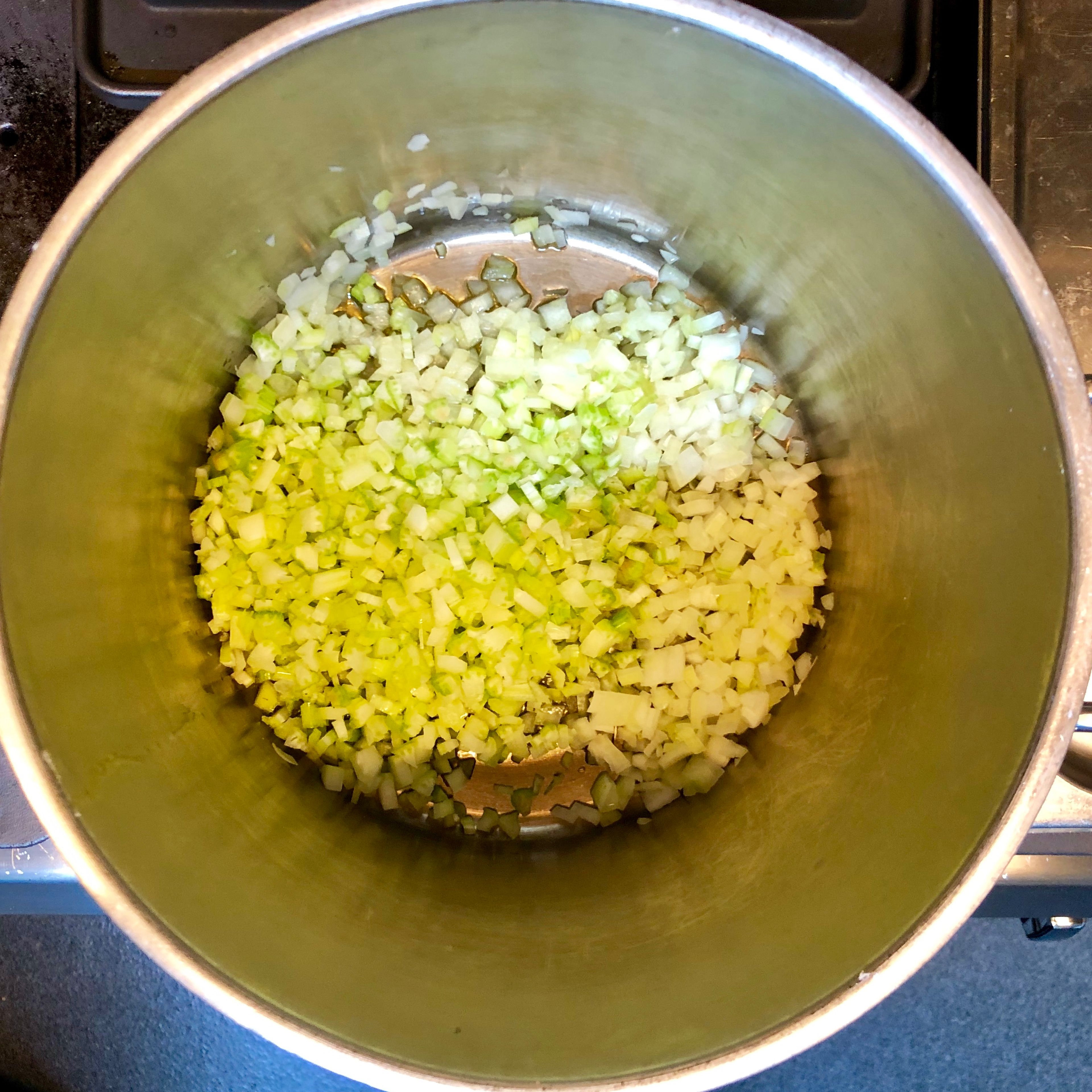 Cut the onion and celery into small cubes and chop the garlic. Combine in a medium size stockpot and cook in a medium heat until soft but not brown.
