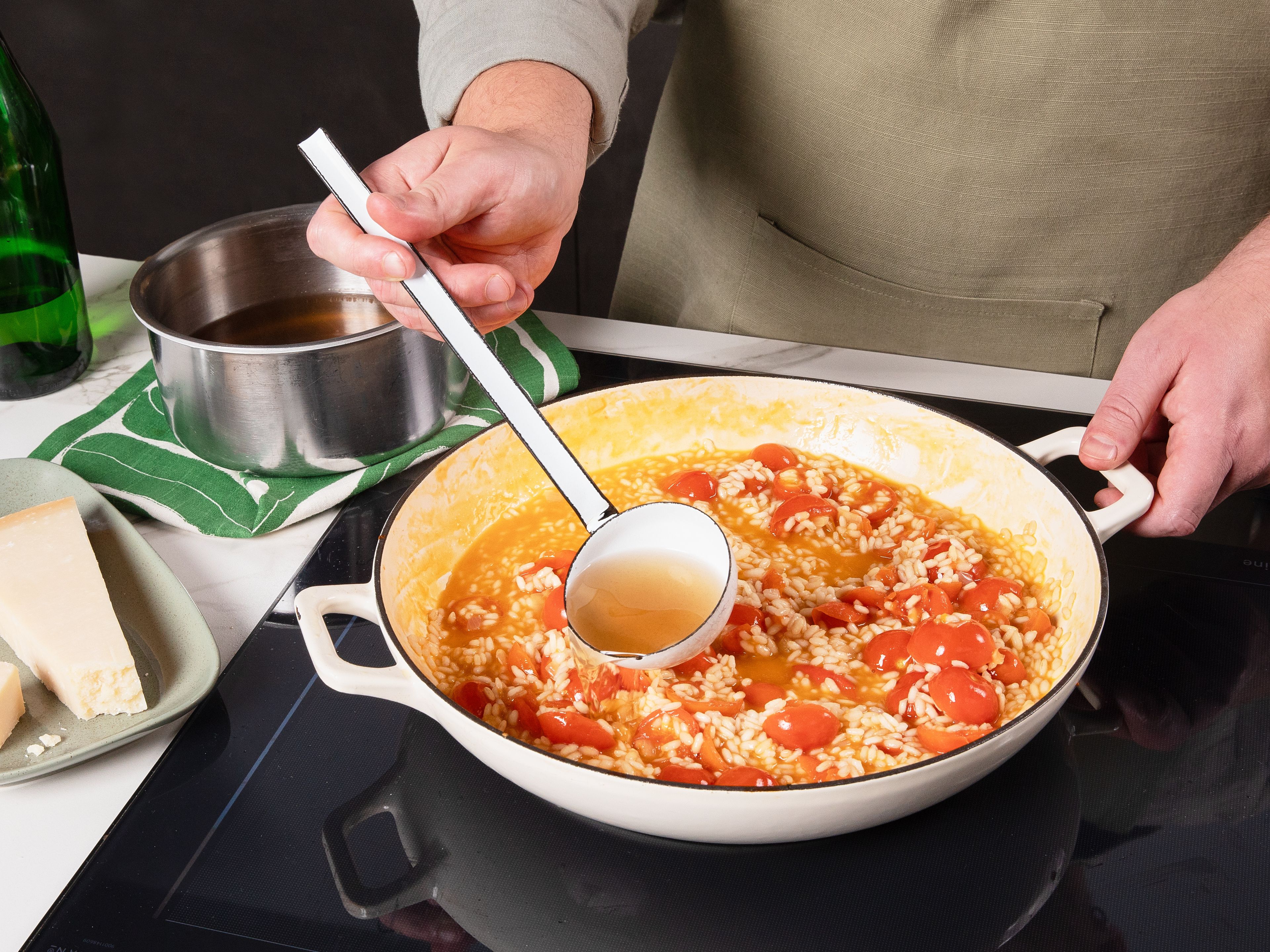 Nun die Tomaten hinzugeben und ca. 1 Min. mitschmoren. Dann mit Weißwein ablöschen und kurz einköcheln lassen. Jetzt etwas warme Gemüsebrühe hinzufügen und unter stetigem Rühren köcheln lassen, bis die Flüssigkeit größtenteils vom Reis aufgenommen wurde, ca. 2 Min. Auf diese Weise schluckweise immer mehr Brühe hinzufügen und unter Rühren köcheln lassen bis noch ca. eine Kelle Brühe übrig bleibt, ca. 15-18 Min. Dann die restliche Brühe, geriebenen Parmesan und die restliche Butter hinzufügen und rühren, bis das Risotto cremig wird, der Reis aber noch etwas Biss hat. Mit Salz und Pfeffer abschmecken.