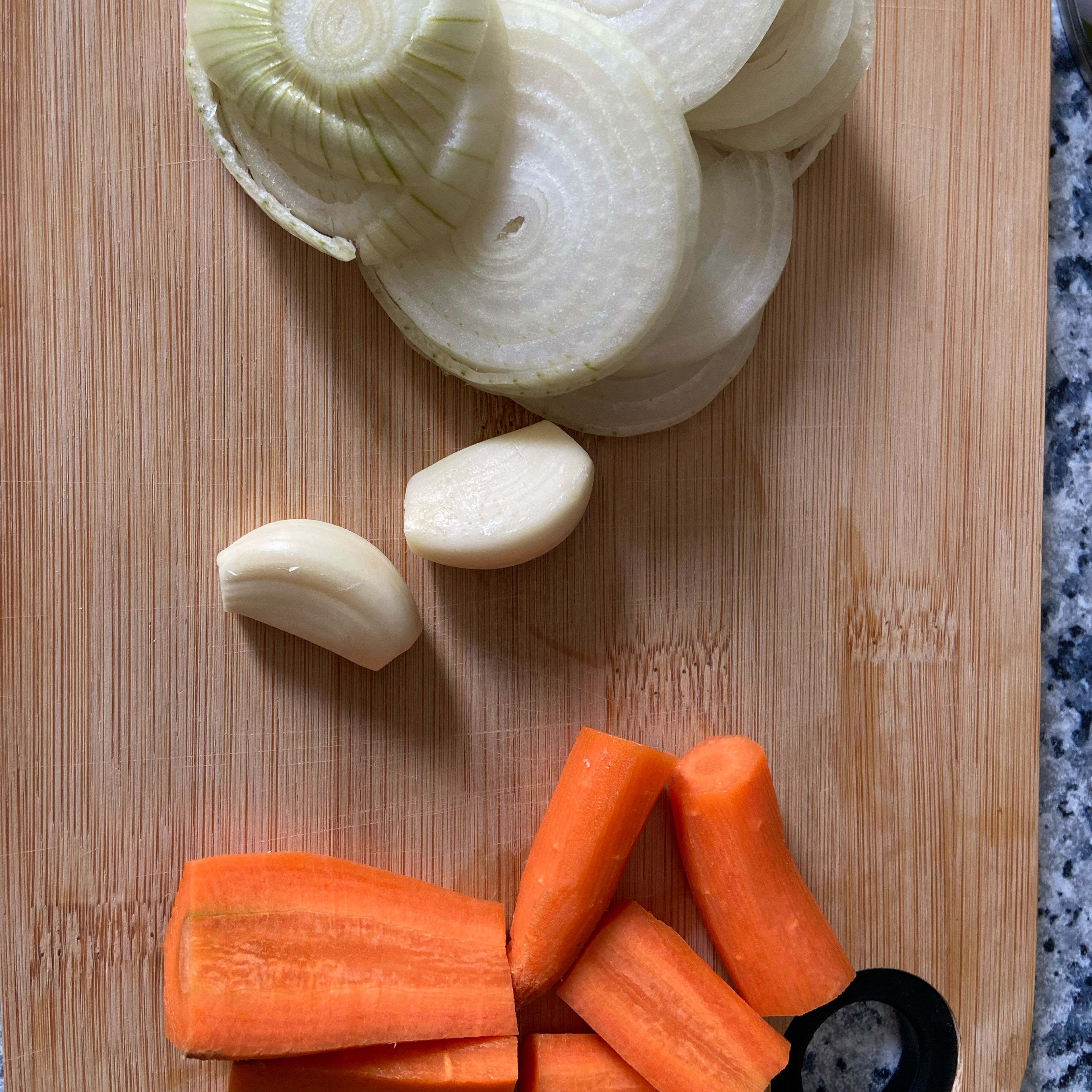 Eine Zwiebel, zwei Knoblauchzehen und eine Karotte schälen und in grobe Stücke schneiden.