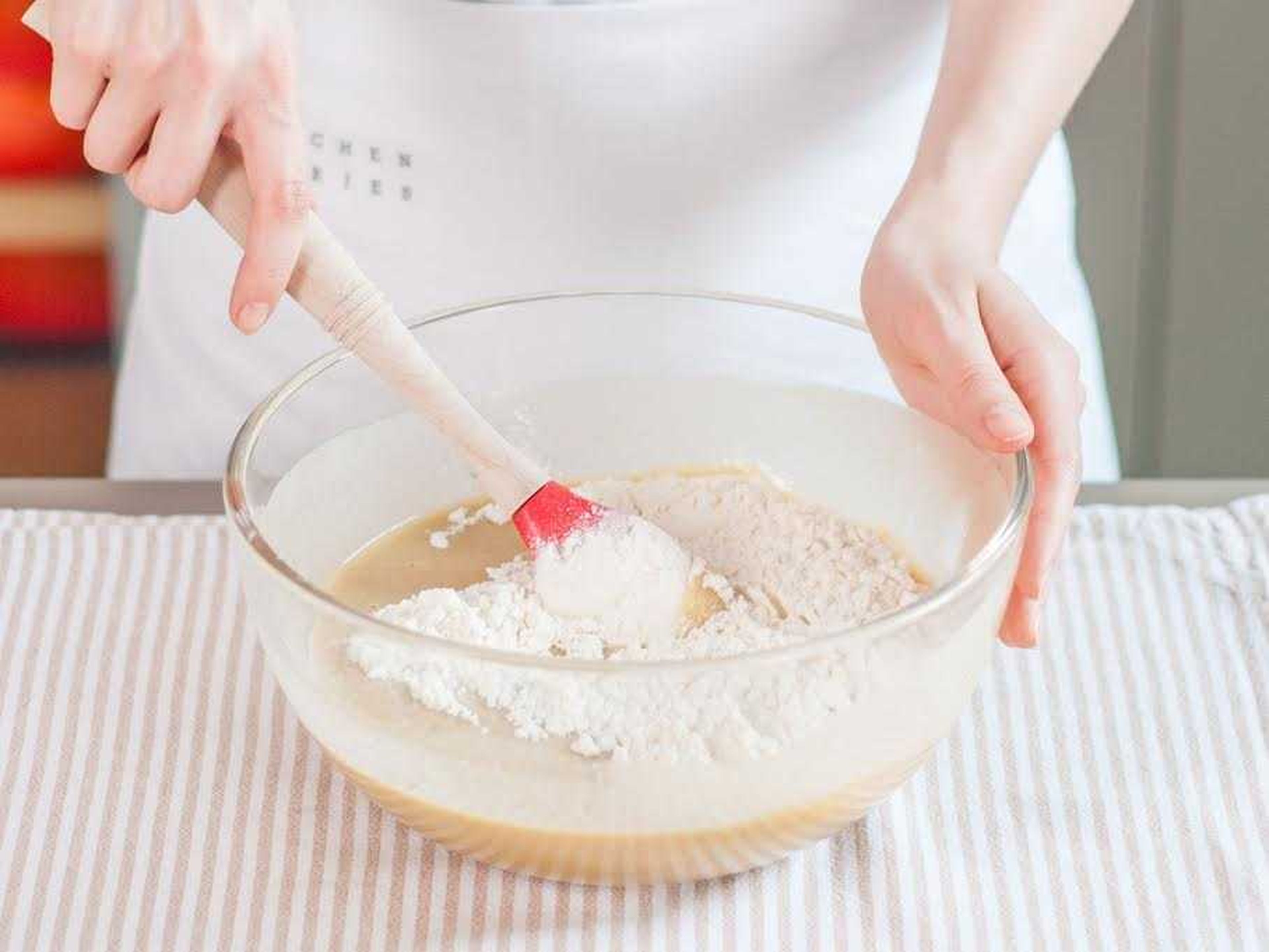 In einer separaten Schüssel Mehl, Backpulver und das restliche Salz miteinander vermengen. Eine Hälfte der Mehlmischung zur Ei-Zucker-Mischung geben. Joghurt unterrühren und anschließend die restliche Mehlmischung hinzugeben und vermengen.