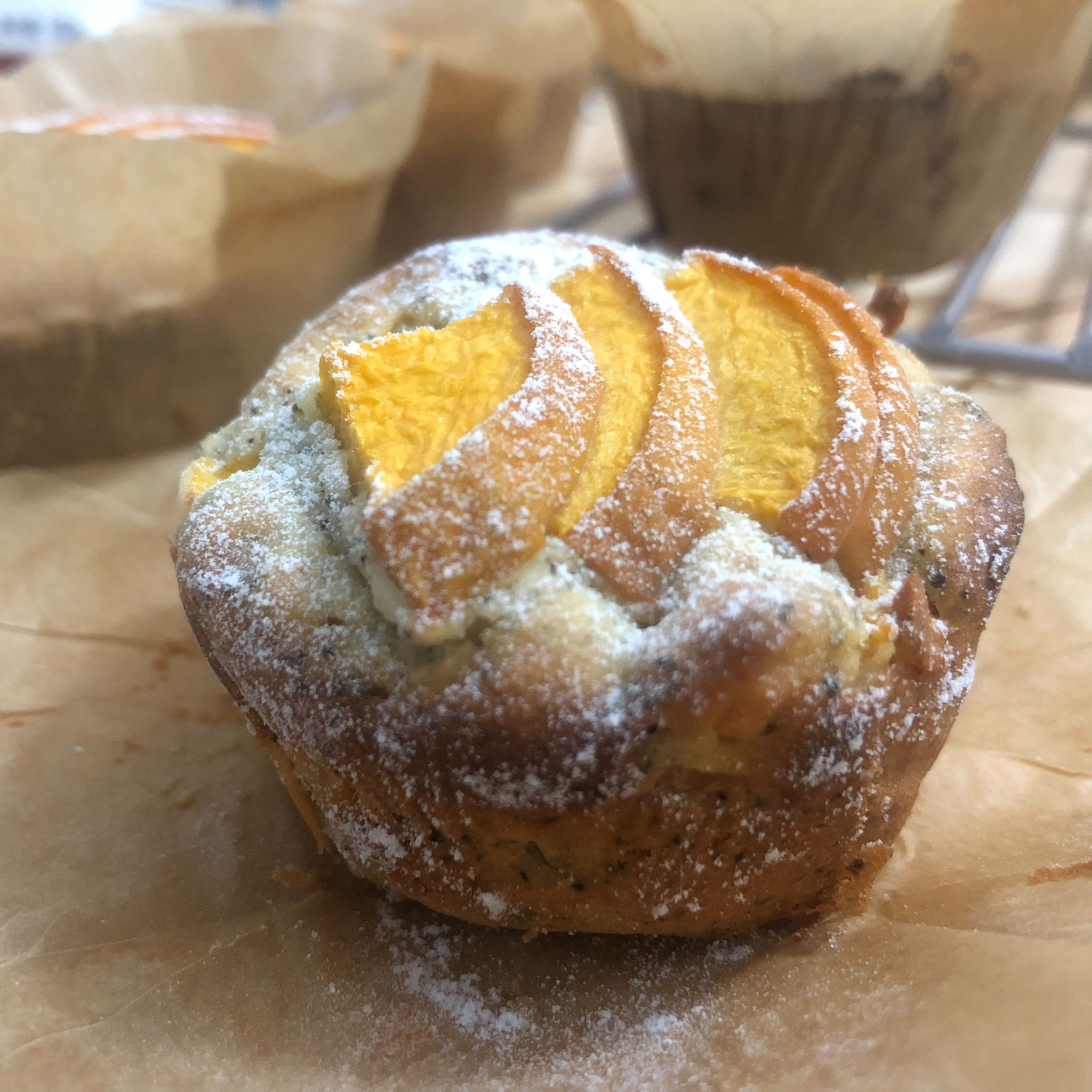 Preheat oven to 170C. Pour into each muffin liner (can use a spoon) and put with sliced peach topping. Then bake at 170C for 25 minuets or till light golden brown. After baking, dust with powdered sugar. Enjoy!