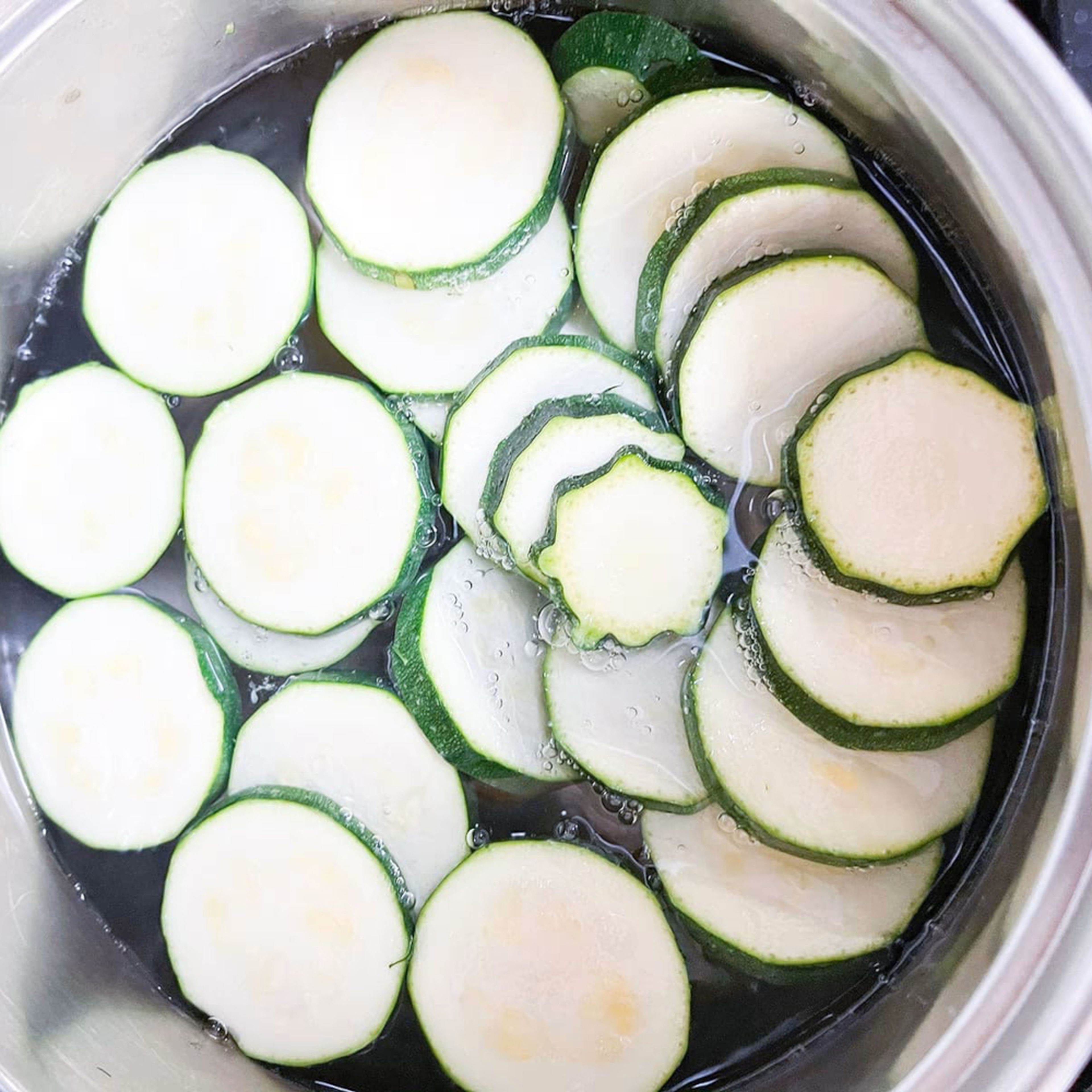 In a bowl, boil the zucchini, half the onion quantity, salt, and pepper for 5 minutes.