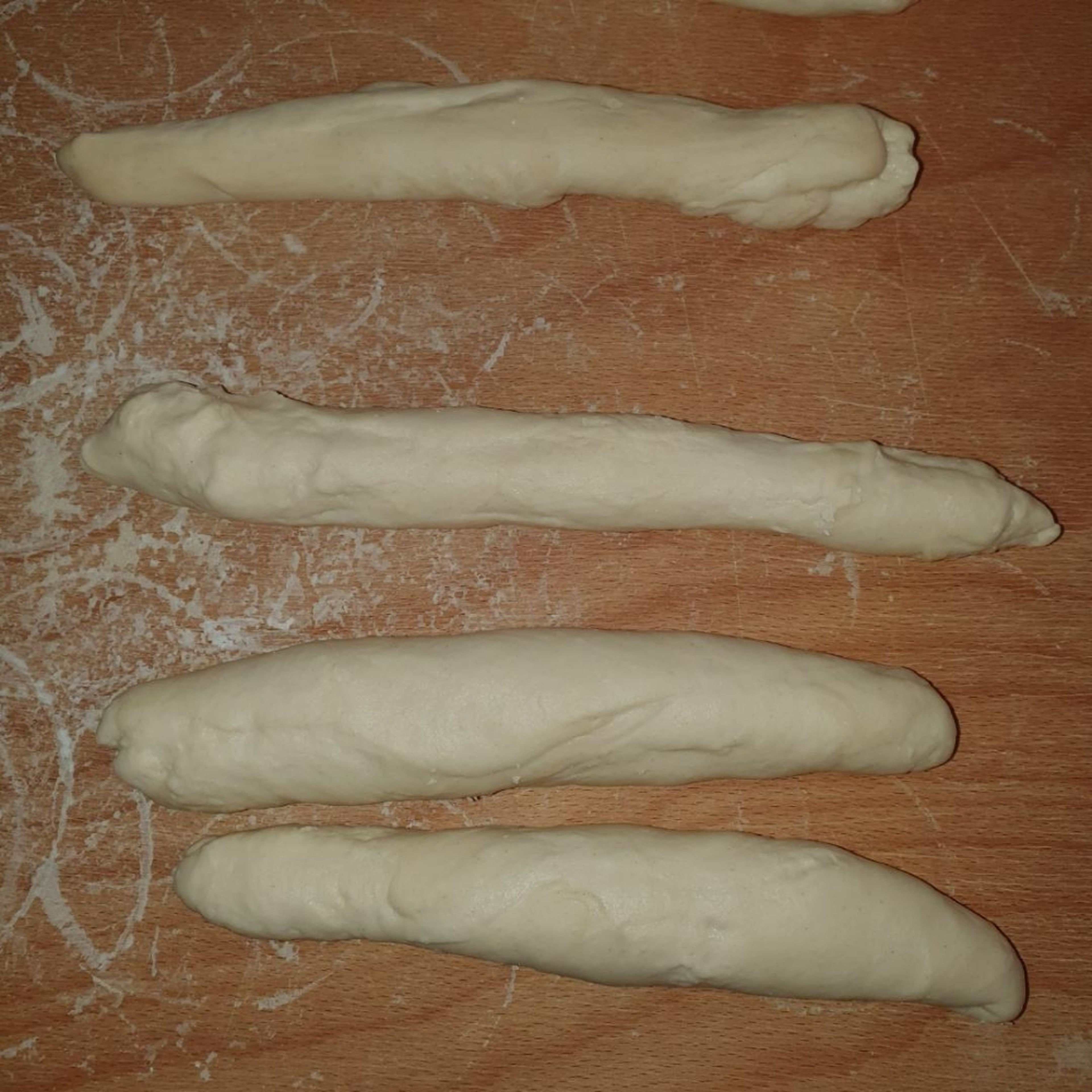 Automatikprogramm für Wasser aufkochen wählen. Wasser in den Topf tun und aufkochen. In der Zwischenzeit die Kartoffeln vierteln. Den Teig zu ca. 20 cm langen, 1 cm breiten Würsten formen.