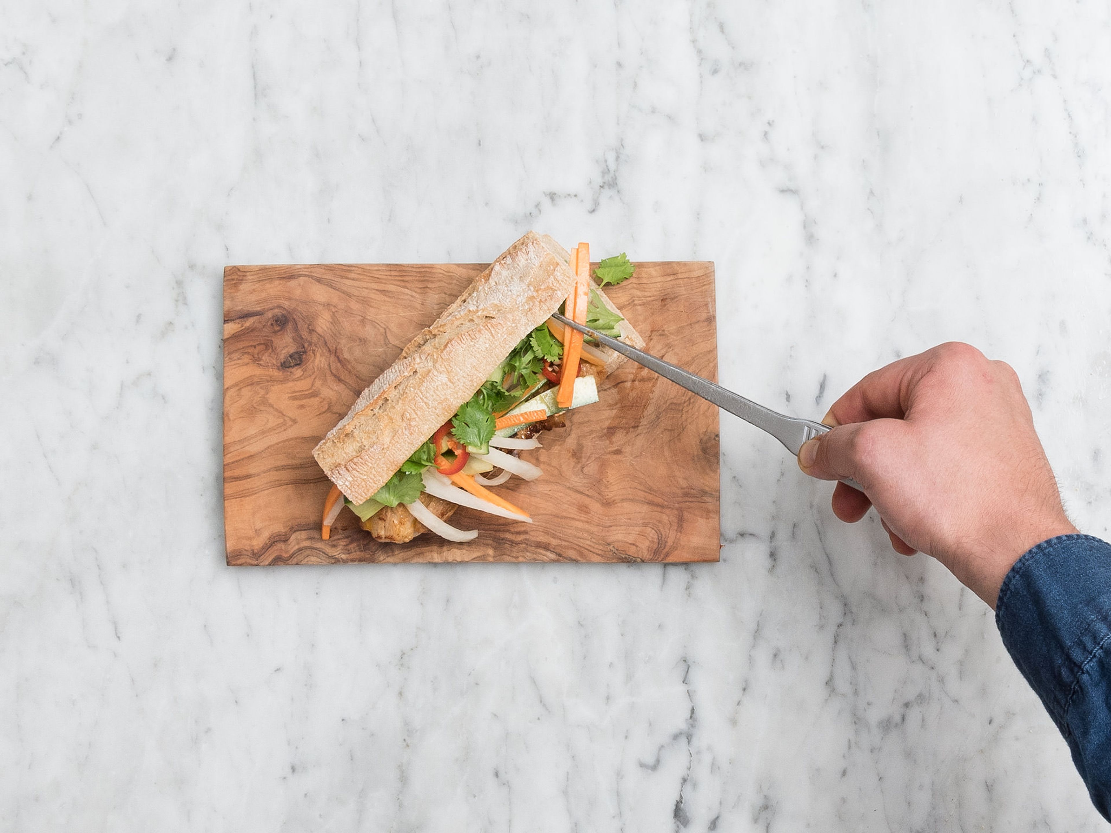 Cut off ends of baguettes and halve crosswise, then cut each piece lengthwise and spread Thai red curry sauce on both halves. Layer with sliced pork belly, quick pickled vegetables, chili slices, and cilantro. Enjoy!