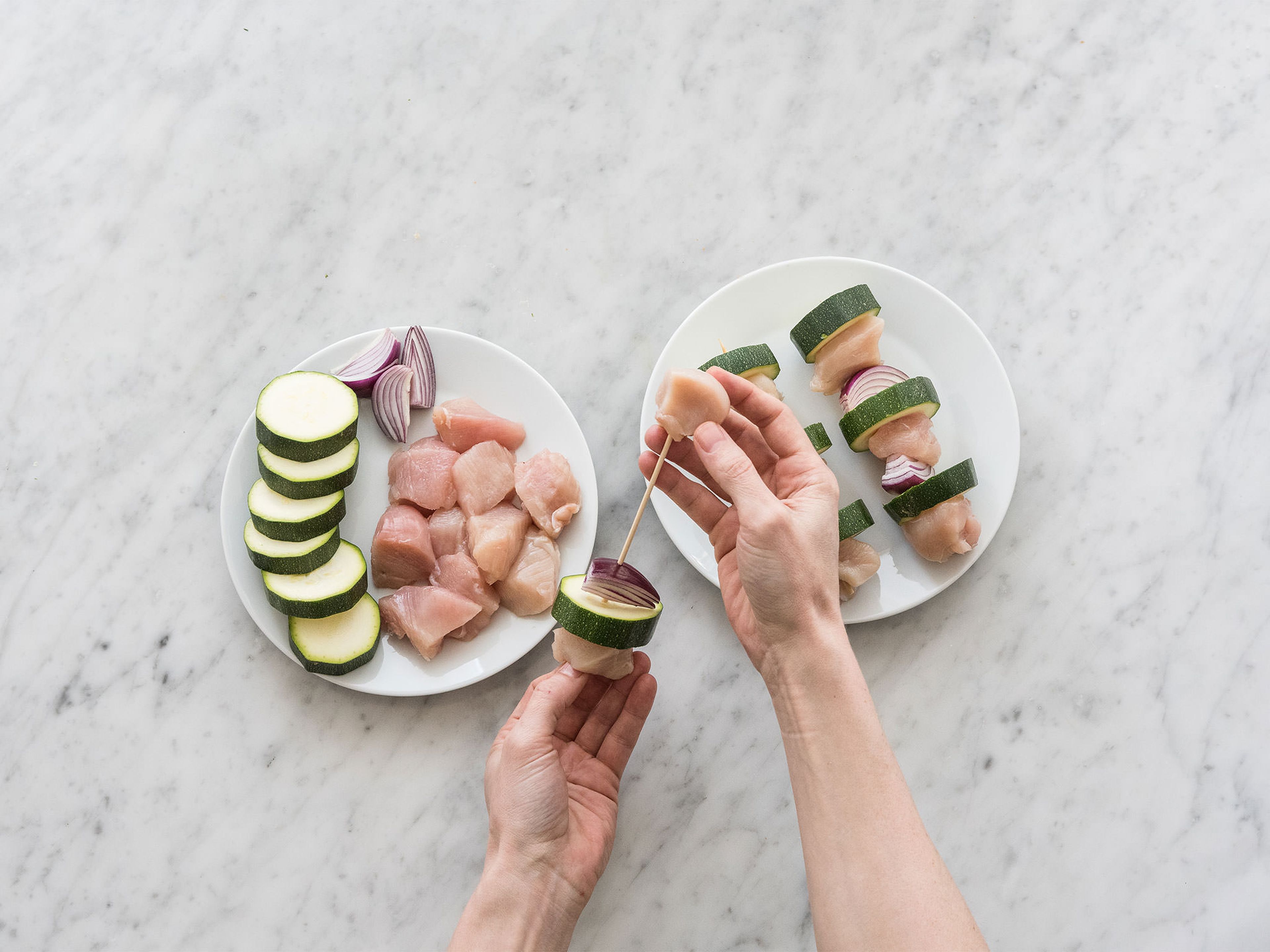 Preheat oven to 200°C/390°F. Thread chicken, zucchini, and red onion onto wooden skewers. In a large frying pan, heat up olive oil over medium heat and sauté skewers for approx. 2 – 3 min. per side. Then, place on a parchment paper-lined baking sheet and place in preheated oven at 200°C/390°F and bake for approx. 10 – 12 min.