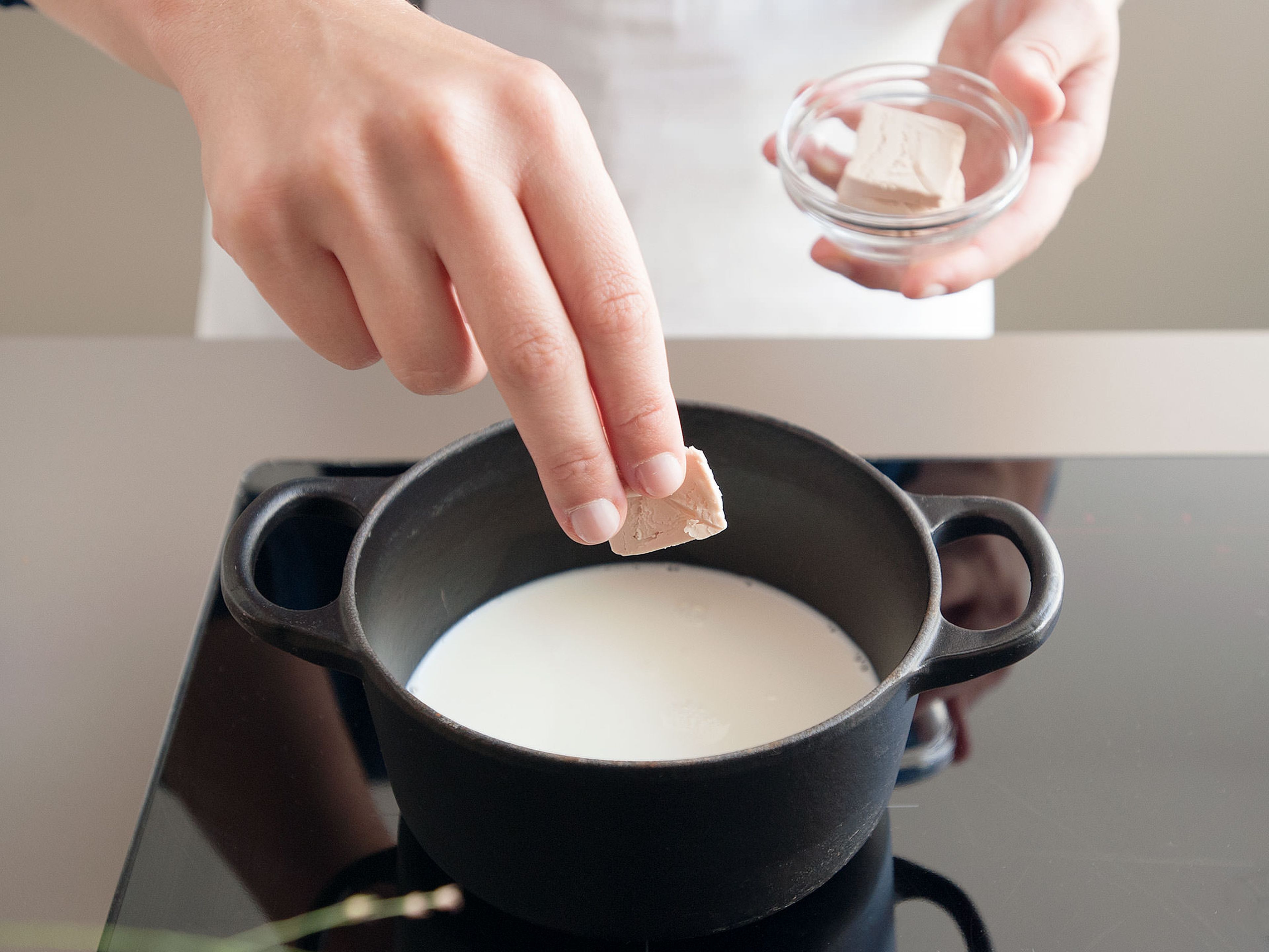 Milch in einem kleinen Topf bei niedriger Hitze lauwarm erwärmen, Hefe hineinkrümeln und eine Prise Zucker hinzufügen. Rühren, bis sich die Hefe auflöst, abdecken und ca. 5 Min. gehen lassen, bis die Hefemilch schaumig ist.