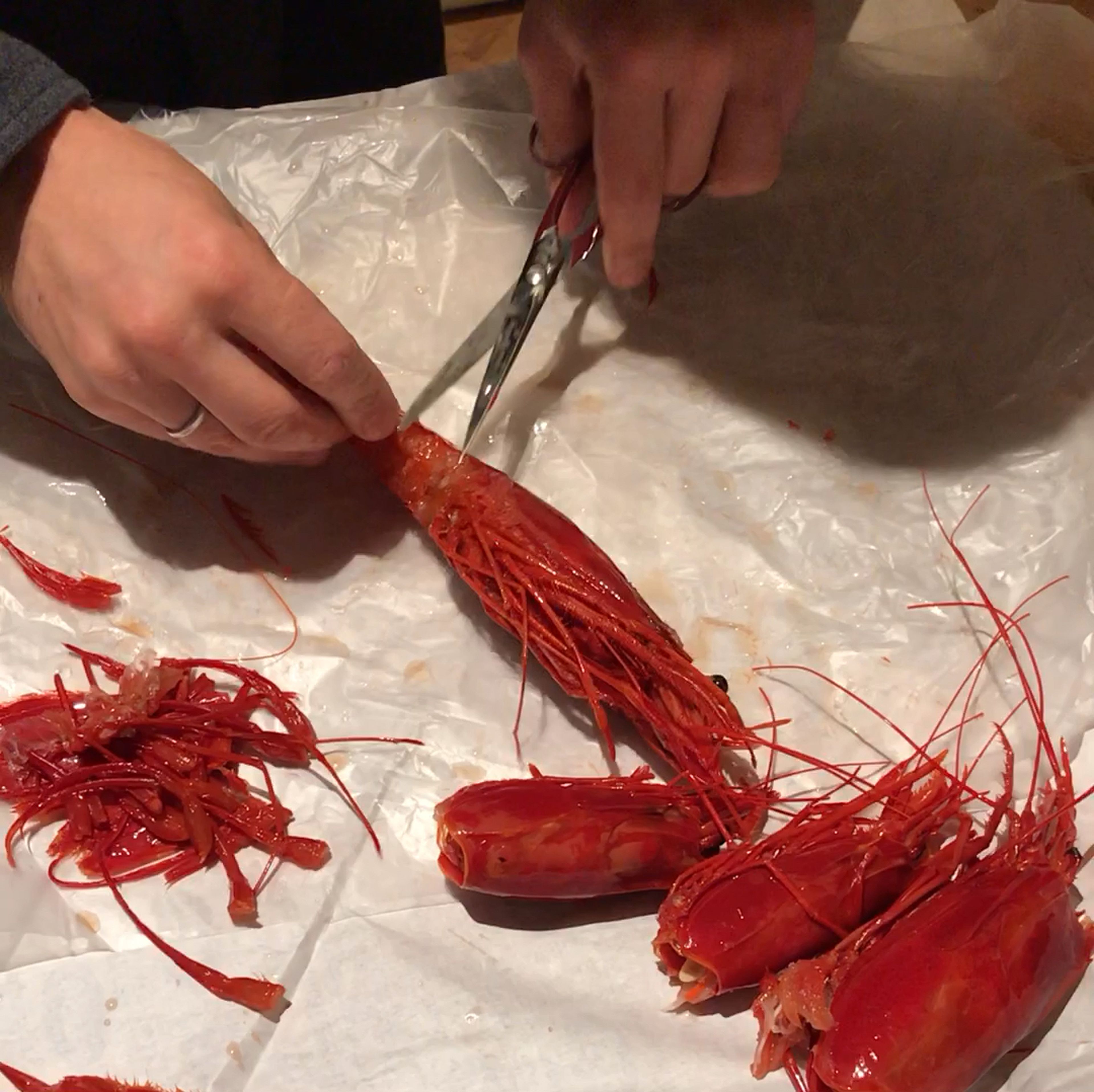 Prepare the Carabineros. Use scissors to cut off swimming legs from the torso. At the end of the tail there are two fins; cut those off as well, leaving the pointy segment in the middle (the telson) in tact. Remove head by twisting the head away from the torso and breaking it off in a downwards stroke.