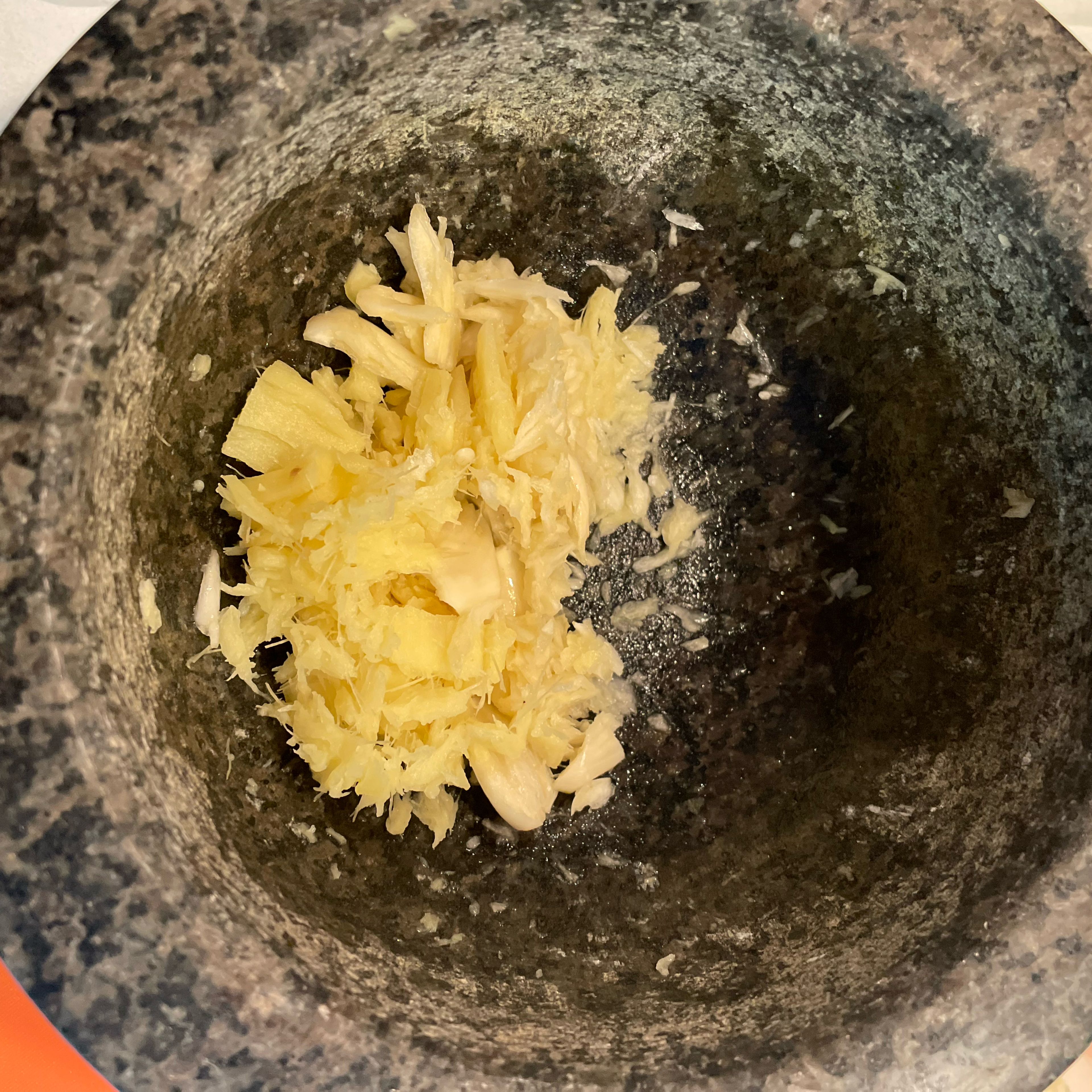 Peel ginger and garlic and crush both with a pestle in a mortar.