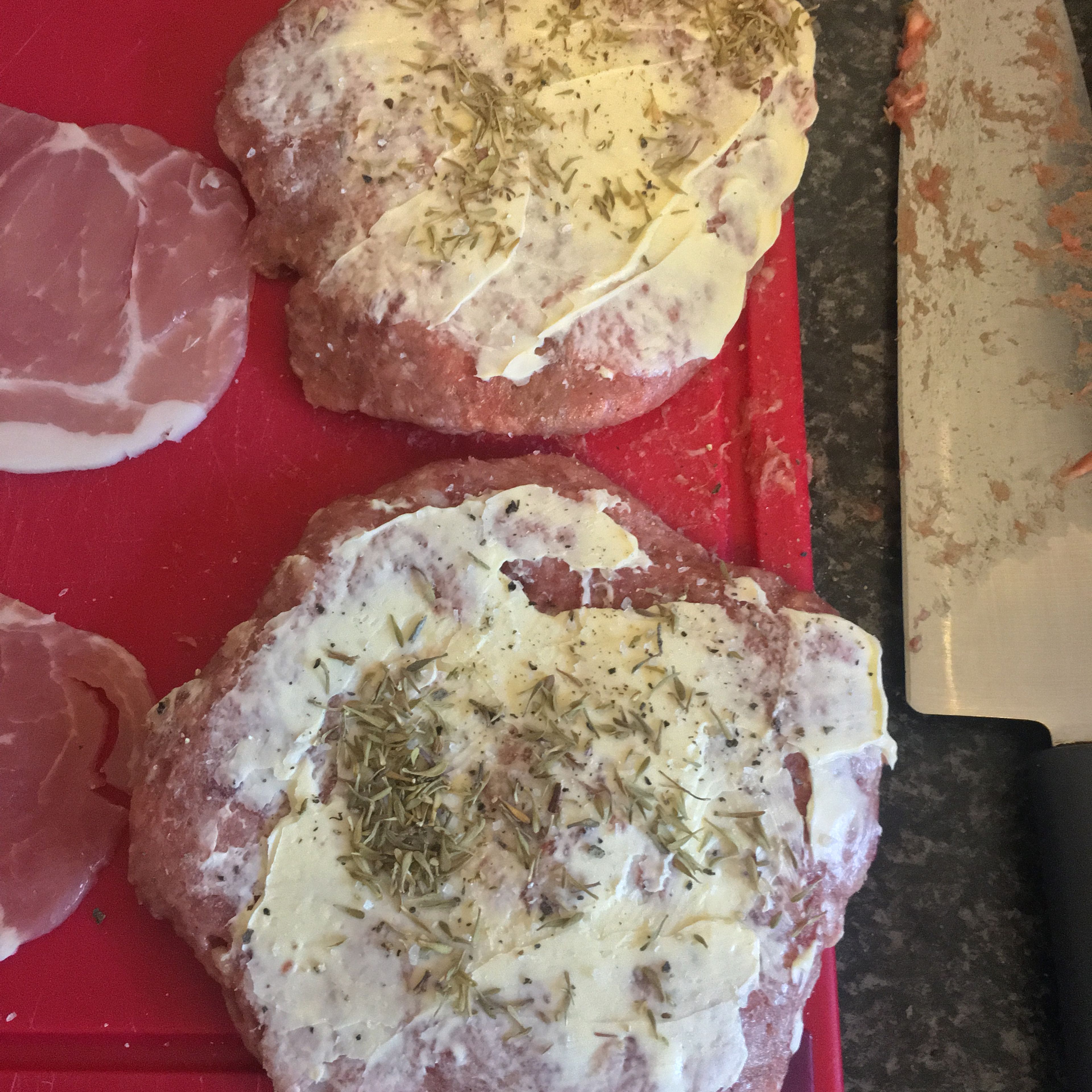 On the chopping board, butter the tops of the burgers then season with salt, pepper and a herb of your choosing (I used Thyme in this recipe).