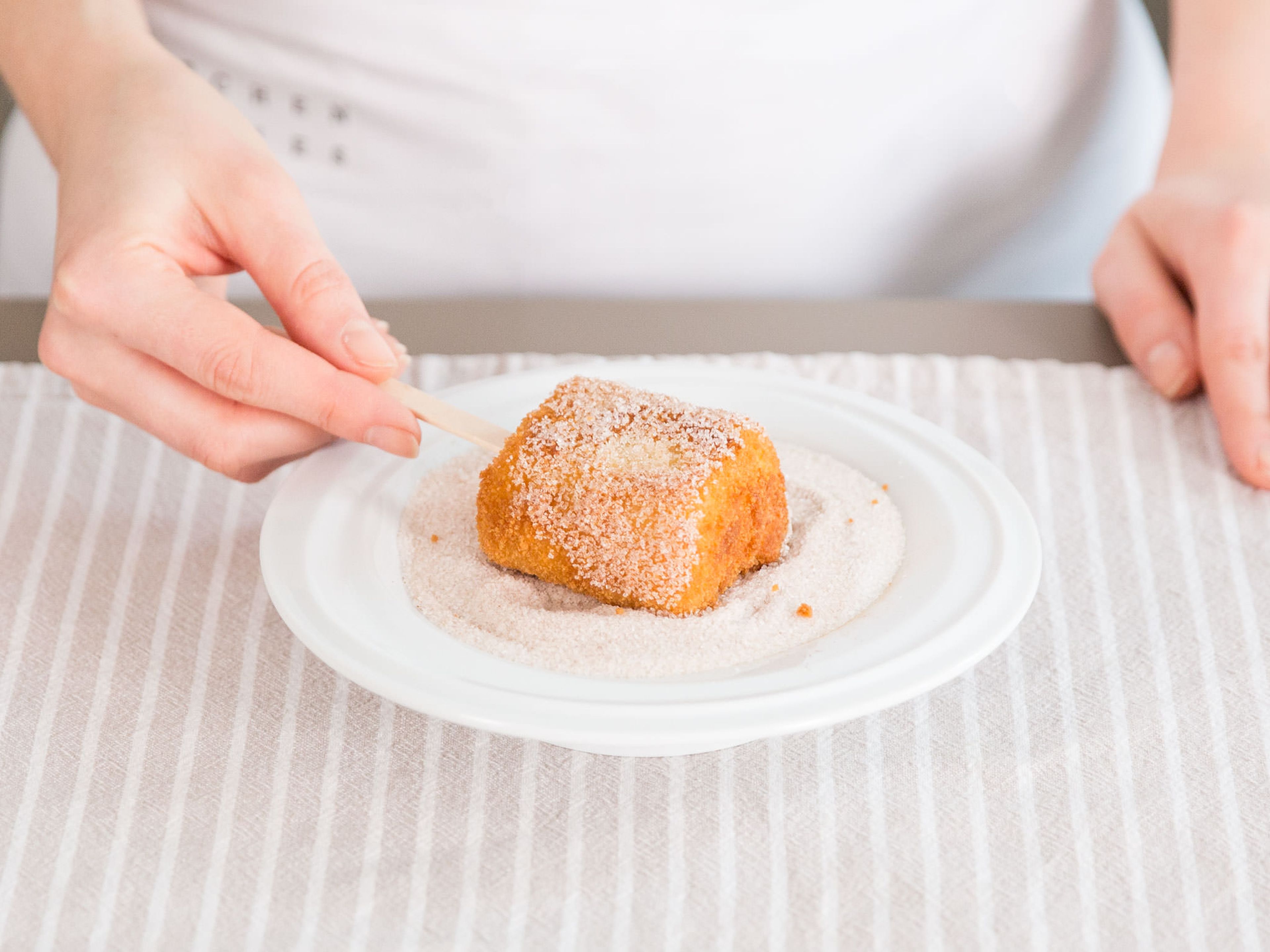 Place an ice cream stick into each fried square. Mix cinnamon and sugar in a deep plate or shallow bowl and roll each square in mixture while still warm. Enjoy!