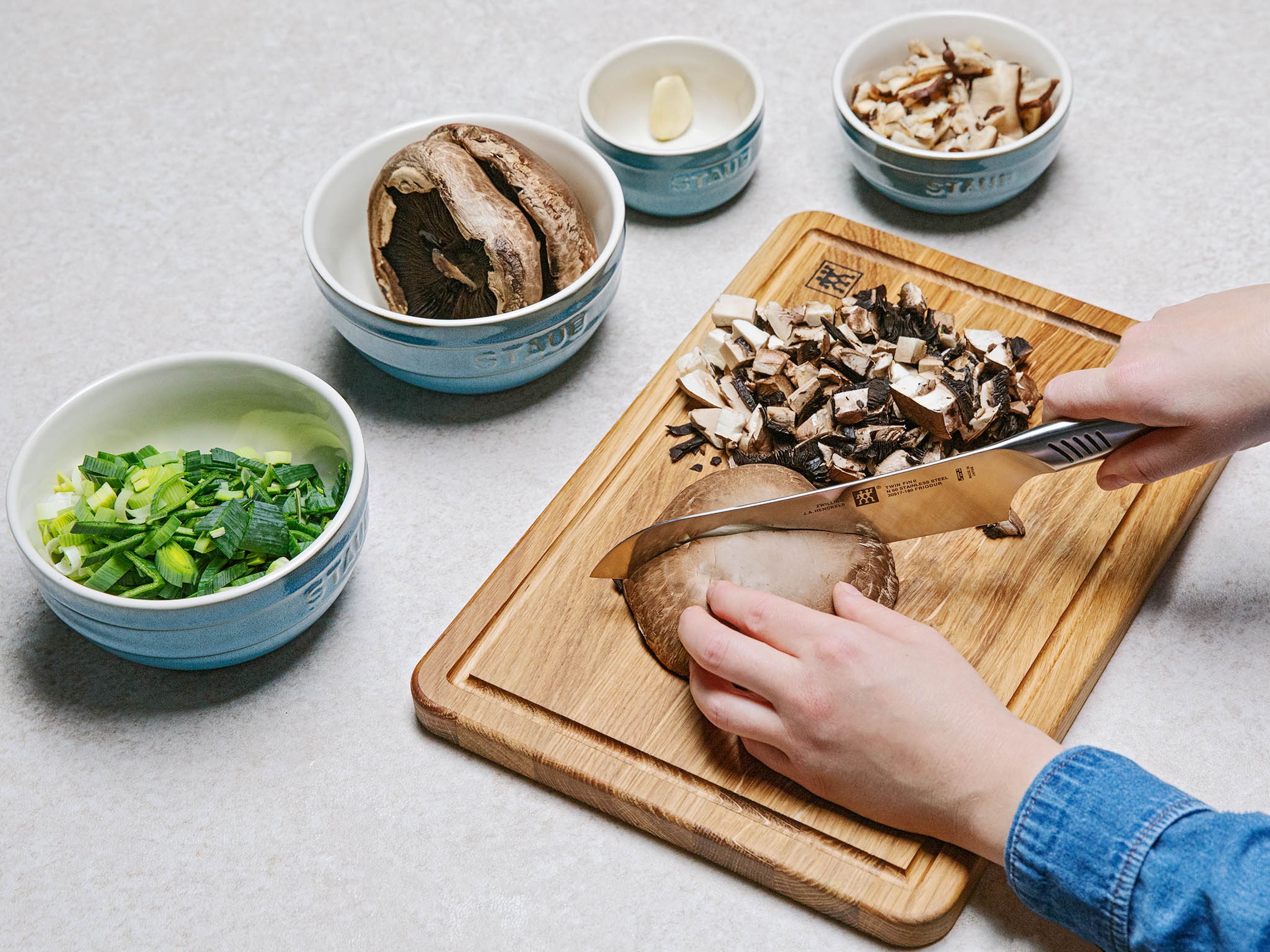 Transfer dried shiitake mushrooms to a heatproof bowl and pour in enough hot water to cover them. Let sit for approx. 20 mins. Thinly slice leeks. Chop portobello mushrooms. Drain and finely chop the shiitake mushrooms. Peel and mince garlic.