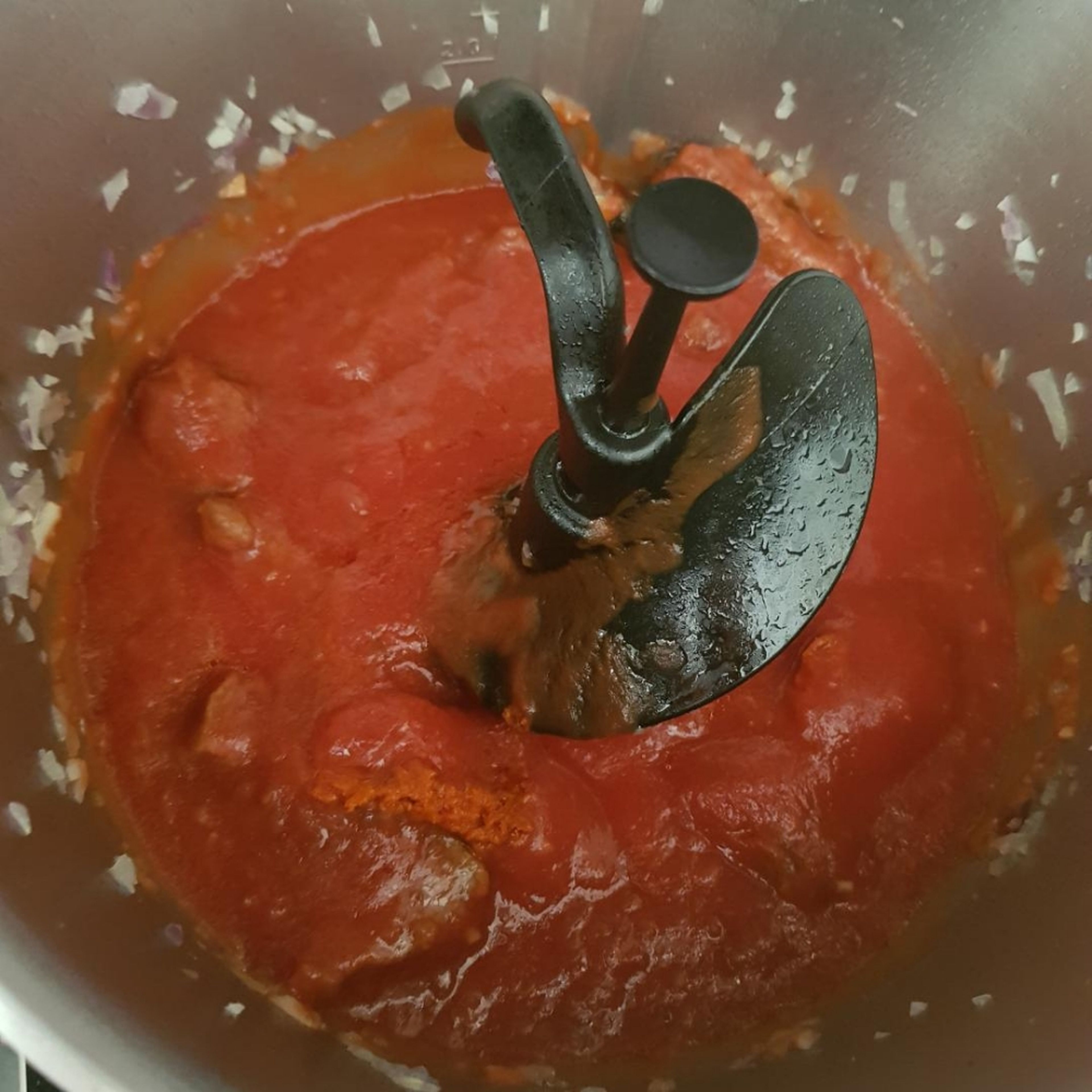 Passierte Tomate und das Wasser einwiegen und 2 TL rote Curry Paste hinzufügen. Deckel schließen, den Messbecher einsetzen und köcheln lassen (3D-Rührer| Stufe 2| 98 Grad | 60 Min.).
